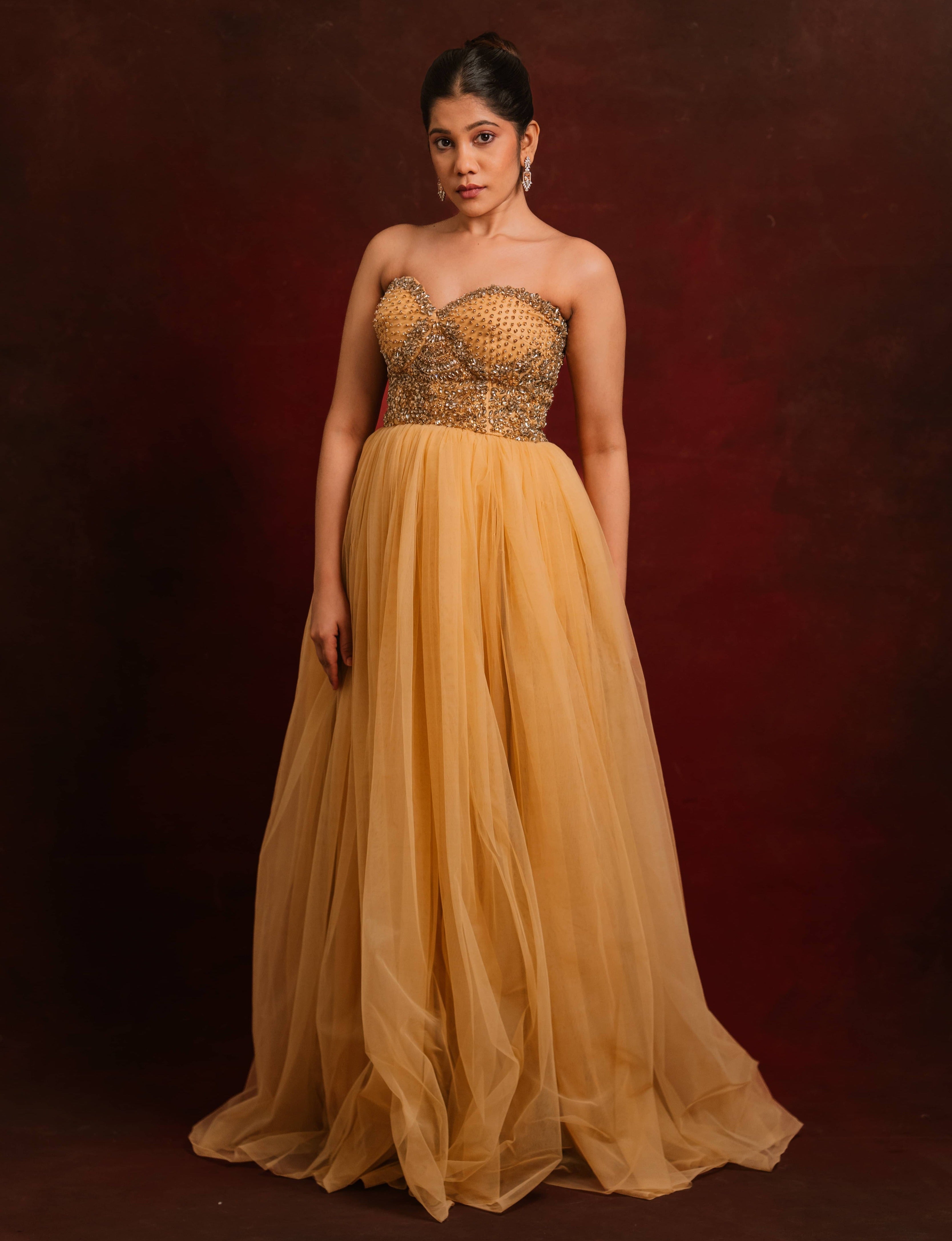 A gold corset dress intricately handcrafted with stones and sequins designed by team Archana Karthick.