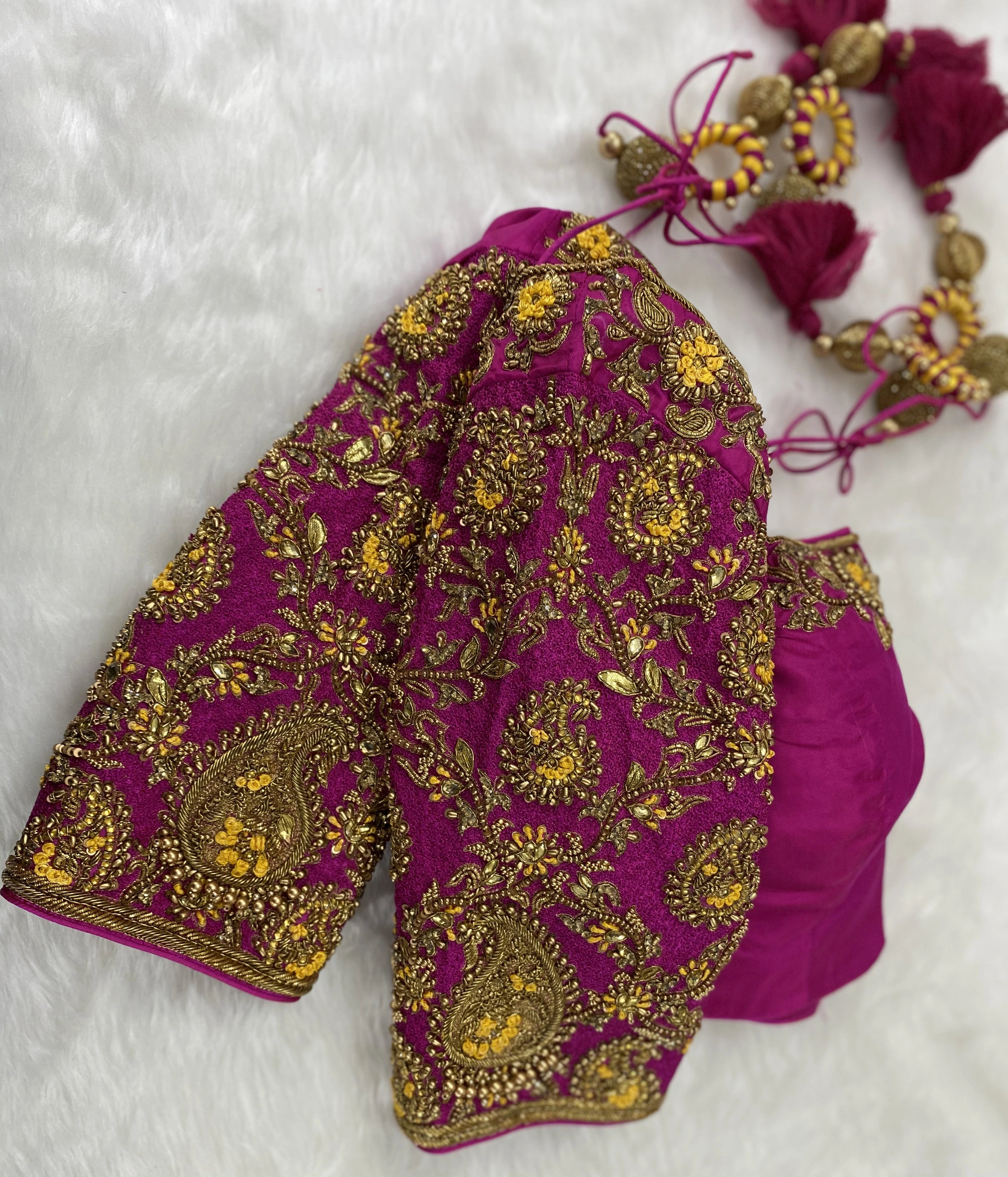 A handcrafted pink raw silk blouse with beads, kundan, zardozi and resham knot work with paisley motifs designed by Archana Karthick