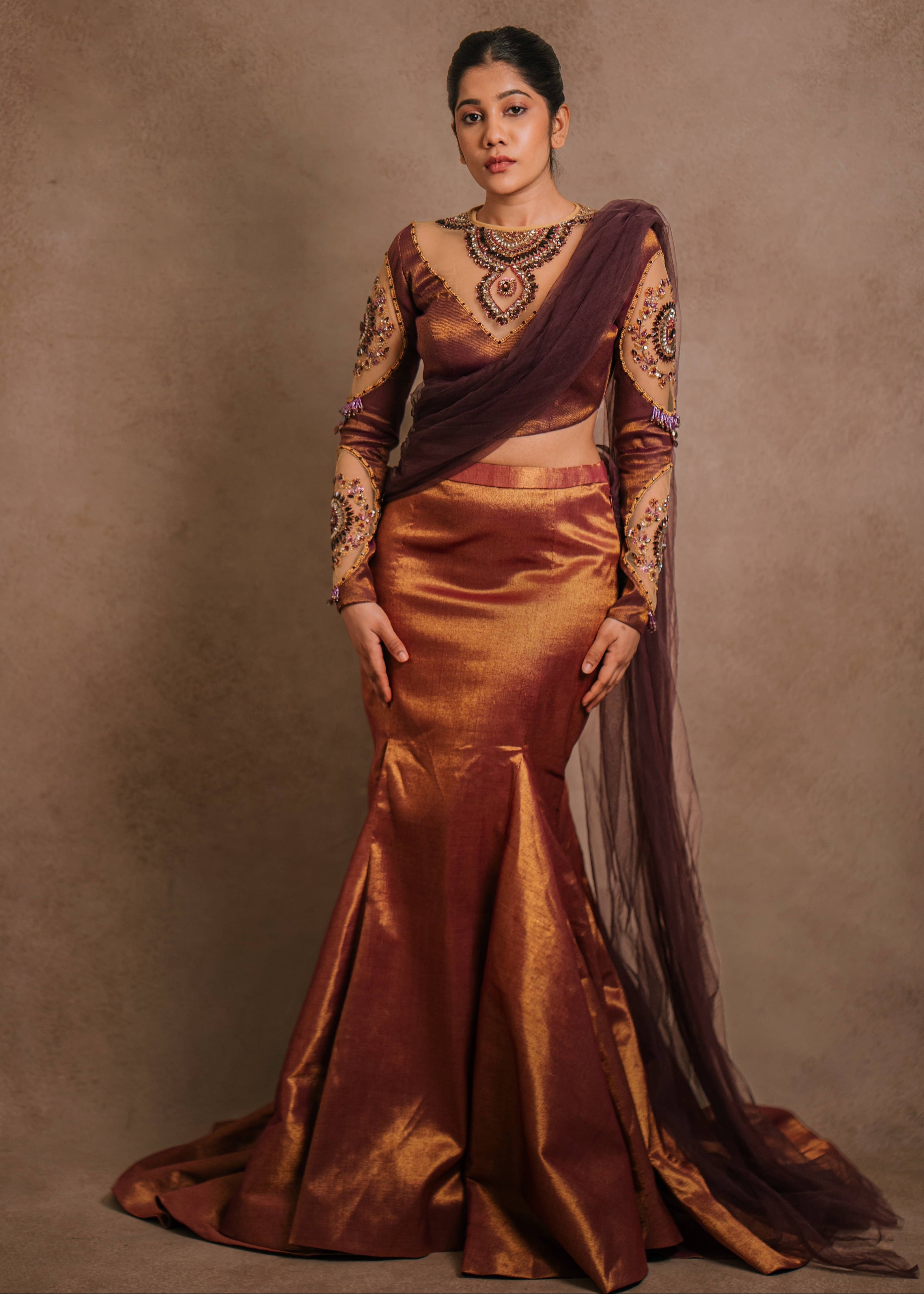 A tissue lehenga with a mermaid skirt & a tulle dupatta intricately handcrafted with stones, crystals, and sequins by team Archana Karthick.