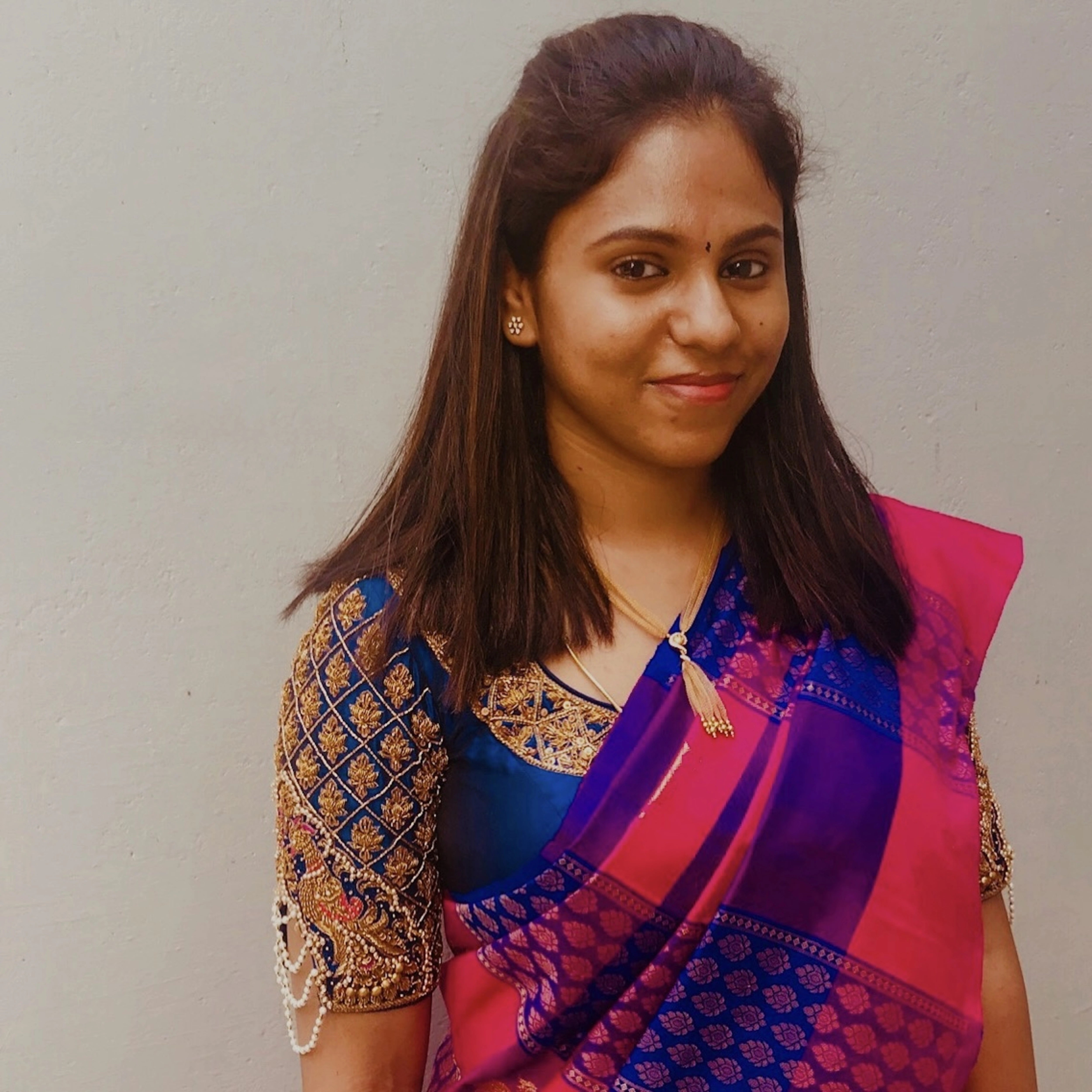 Abhinaya smiling in a blue silk blouse for her house-warming ceremony, handcrafted with zardozi, pearls, beads, knotwork, cutdana and sequins by team Archana Karthick.