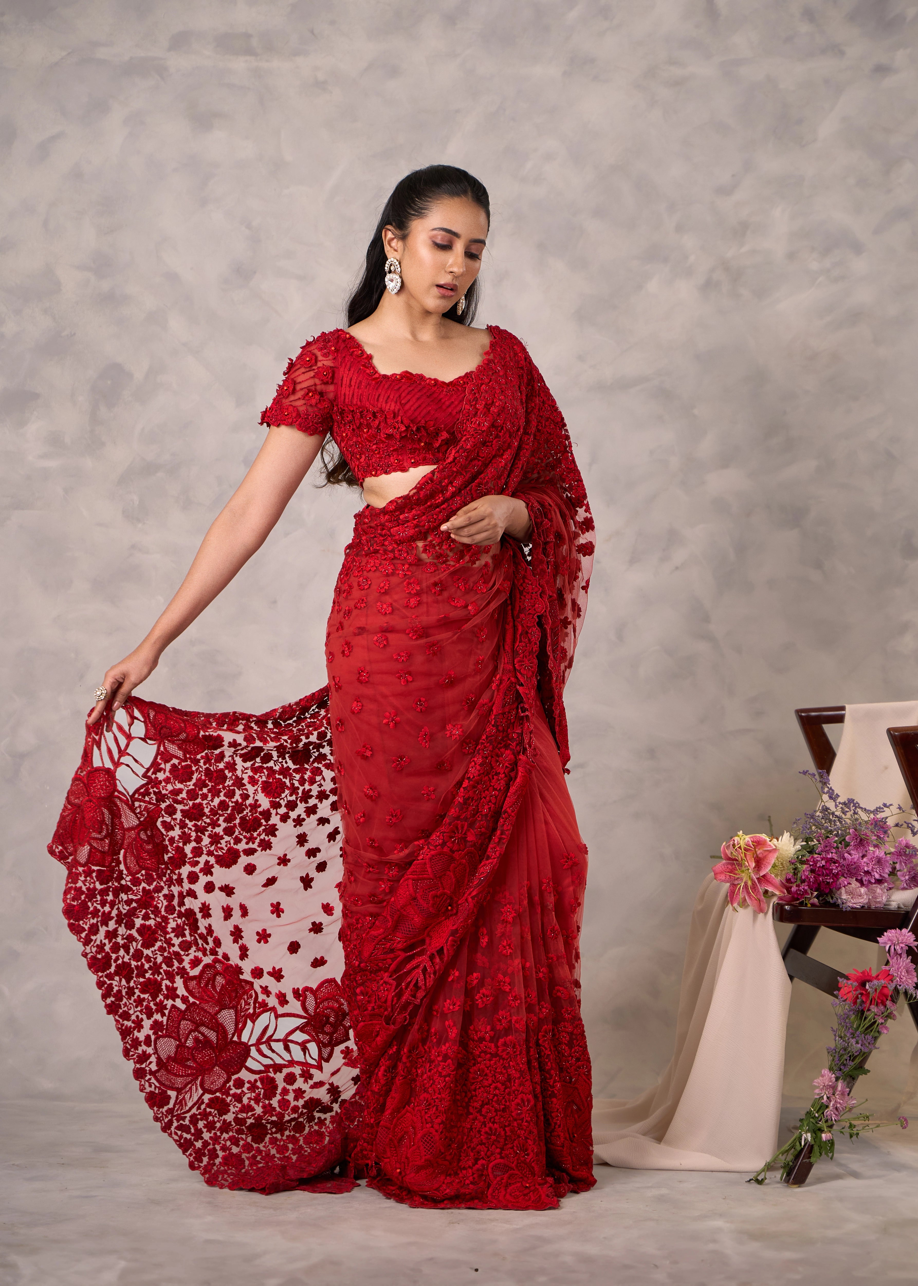 Actress Akshaya Hariharan stuns in red net saree with floral motifs. Bridal & festive wear.