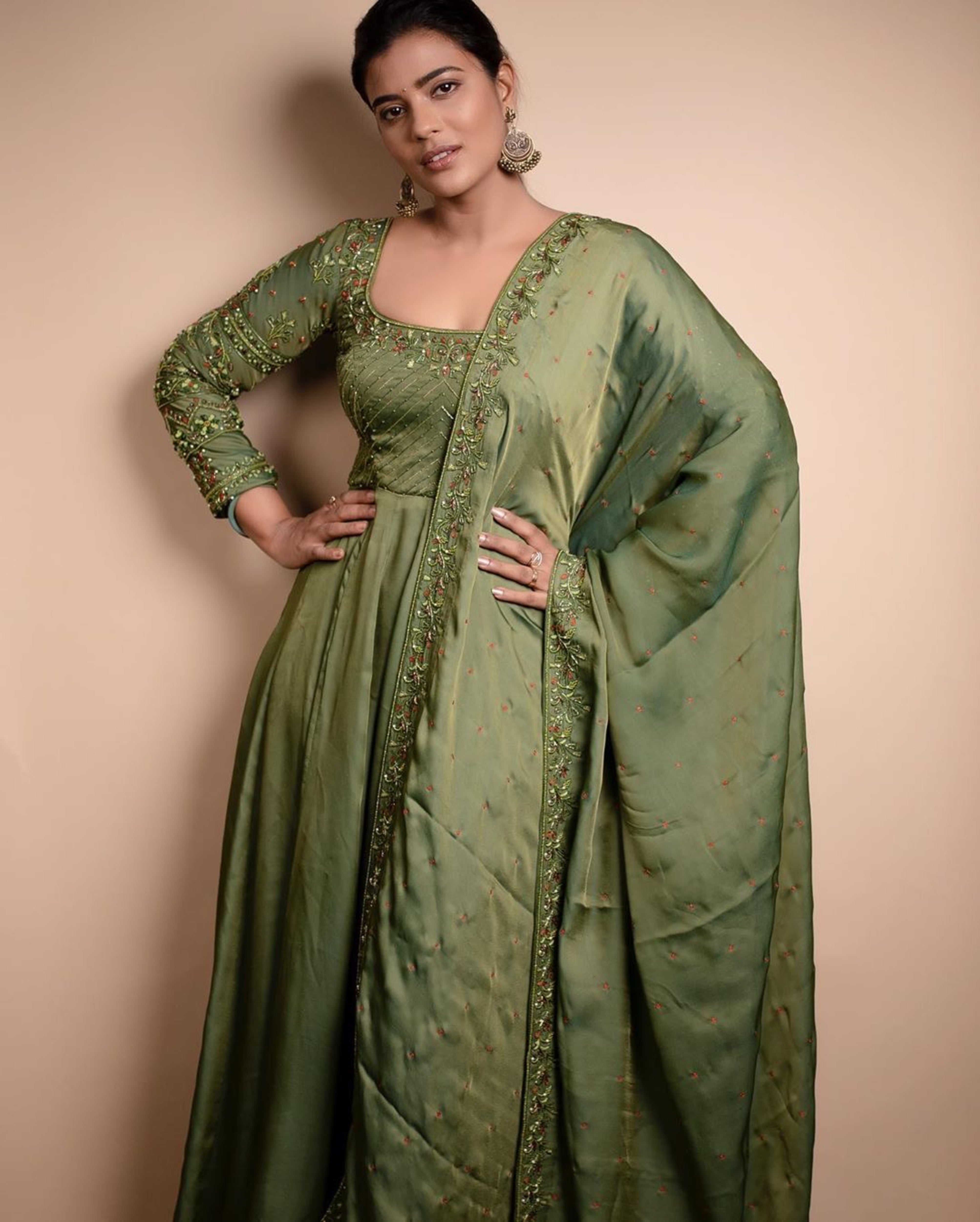 Actress Aishwarya Rajesh in a handcrafted green malkha silk anarkali posing at camera with a smile