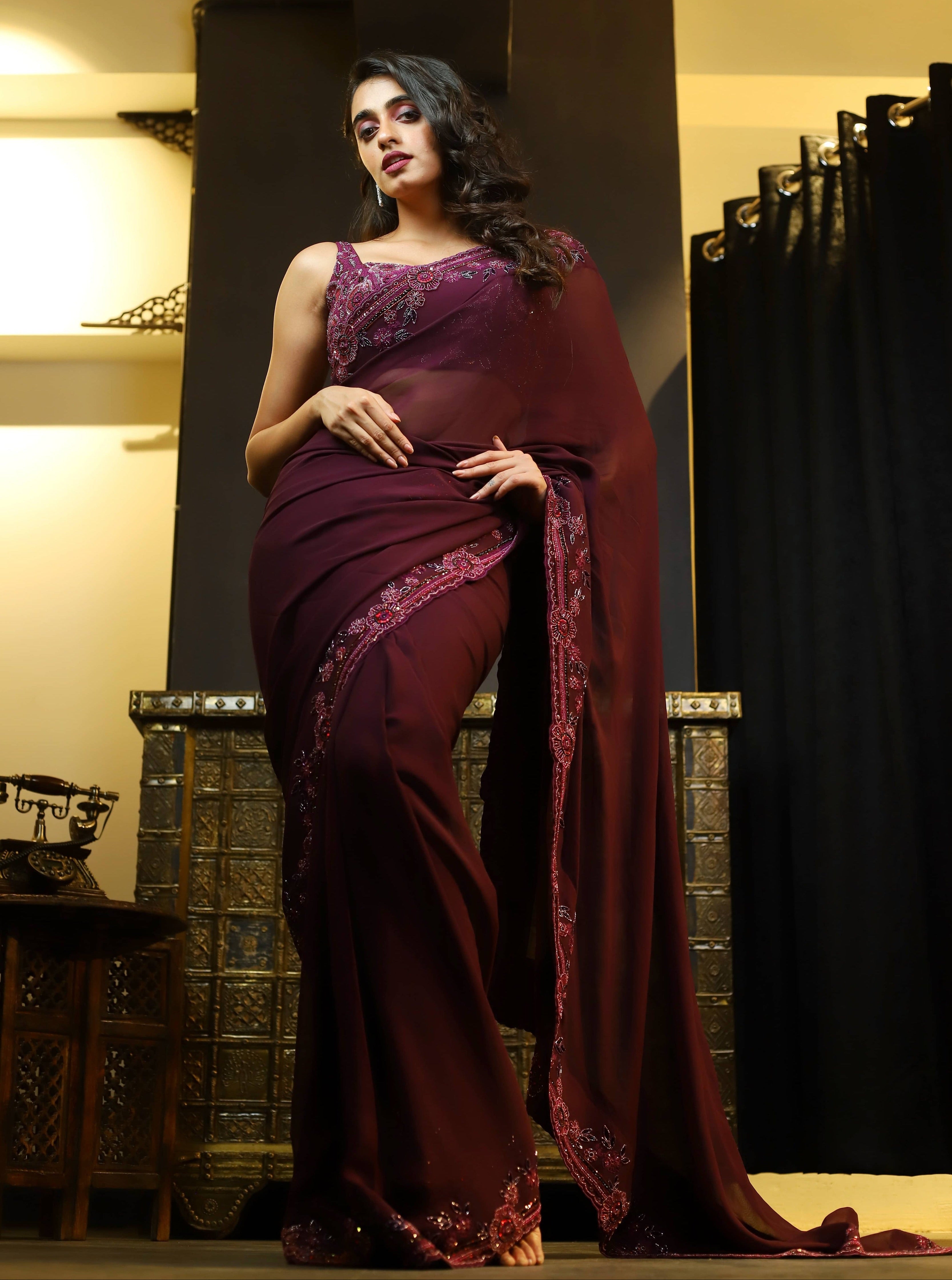 Actress Cherukuri Maanasa Choudhary who acted in the movie Lucky Baskhar with Dulquer Salmaan is seen here in an eggplant aubergine colored georgette saree and embellished blouse.