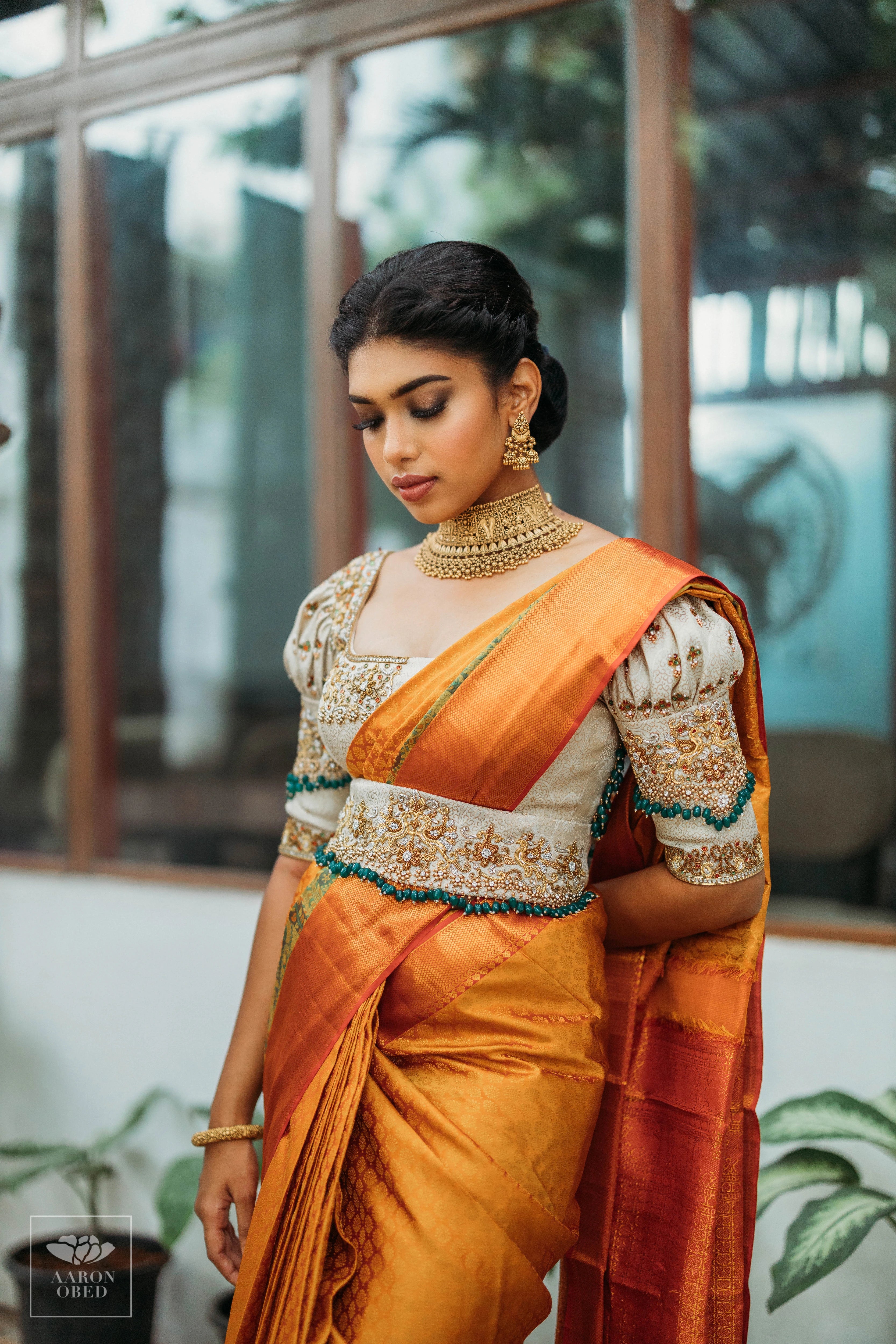 Actress Dushara Vijayan looking down in a concept ivory brocade blouse and belt, intricately handcrafted with zardozi, beads, crystals, zari and kundan.
