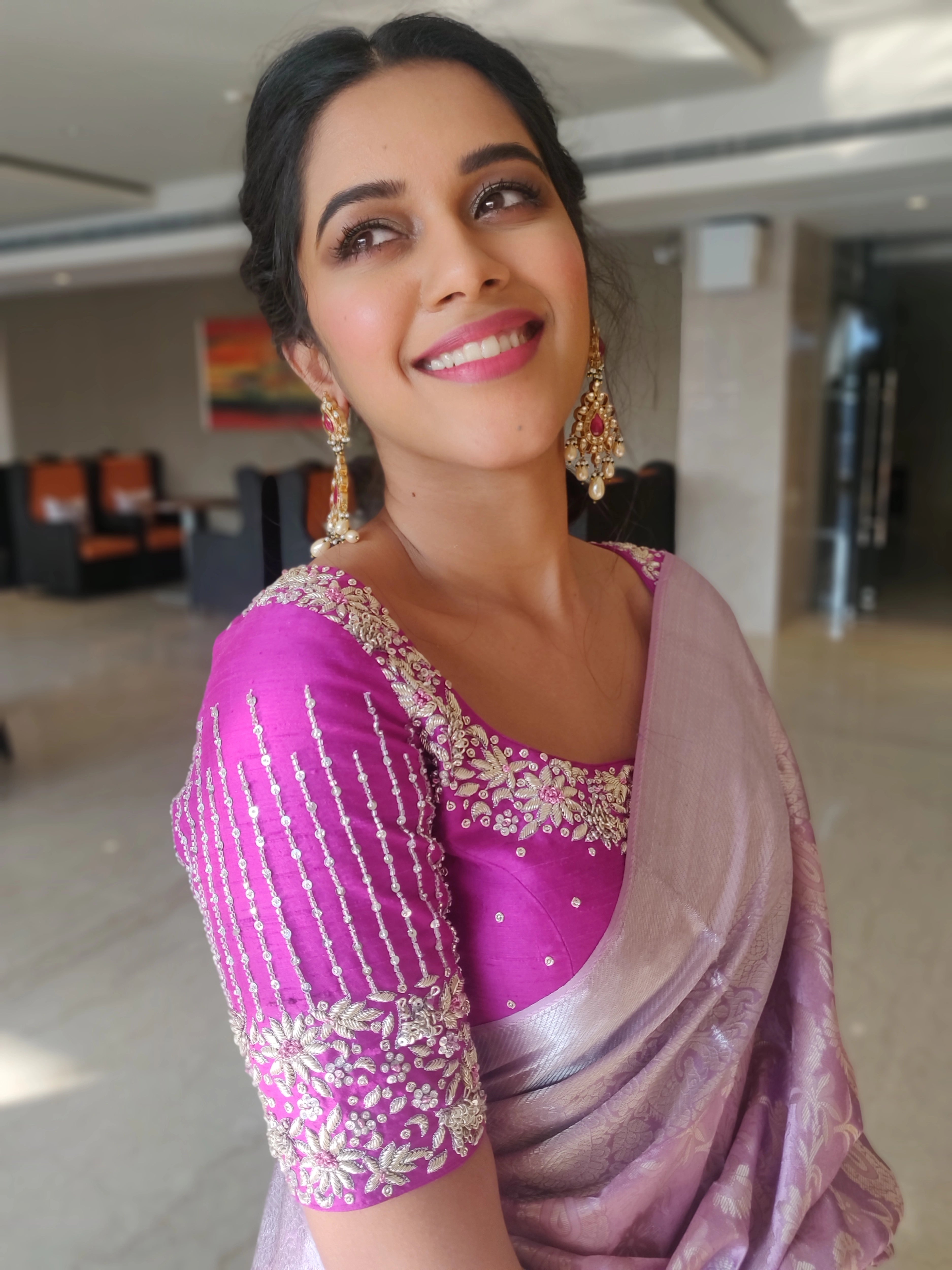 Actress Mirnalini Ravi looking up in a magenta raw silk blouse designed by Archana Karthick handcrafted intricately with zardozi, sequins and stones.
