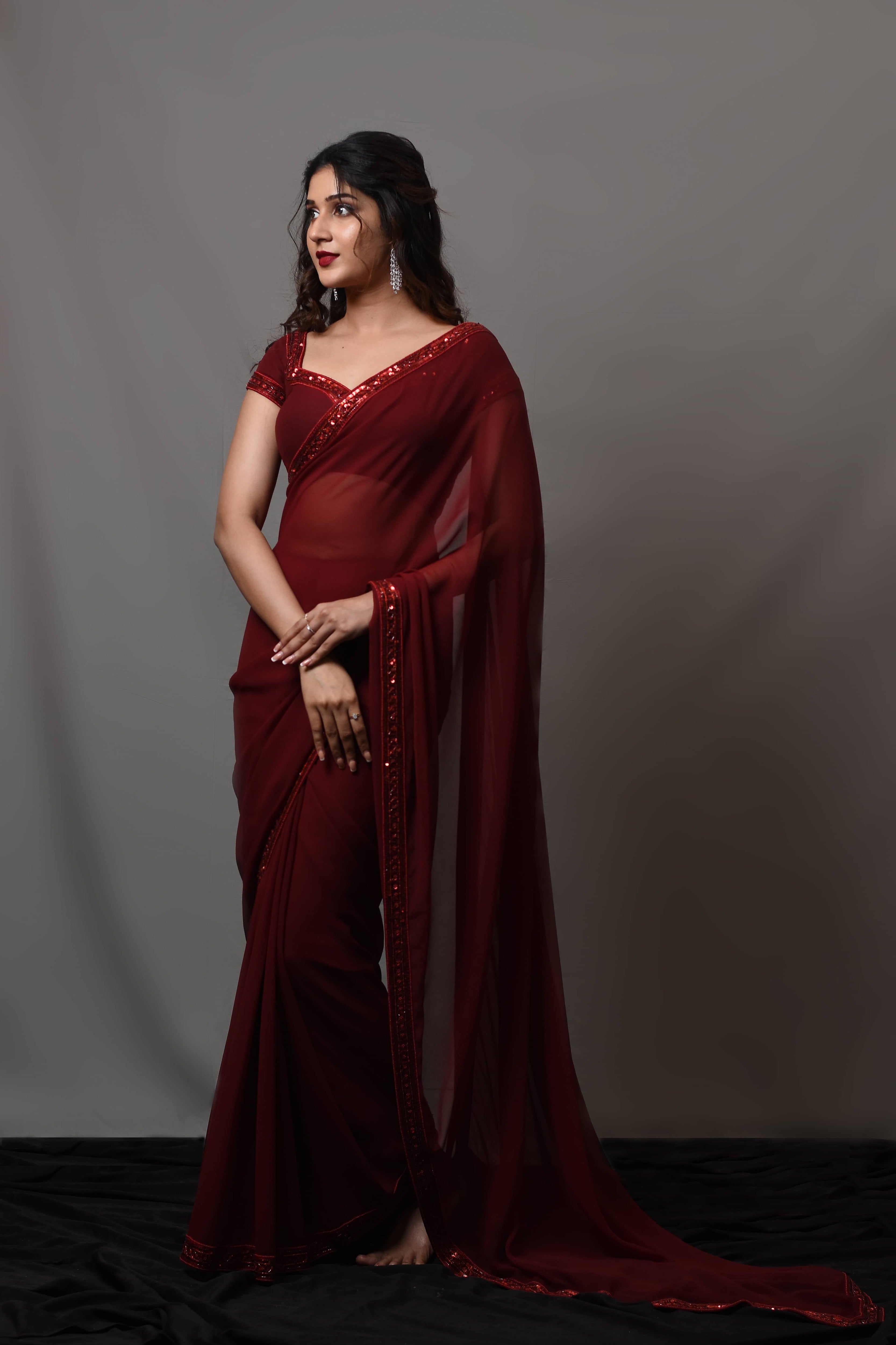 Actress Rabiya Khatoon in a ruby red georgette saree set designed by Archana Karthick. Full front profile.