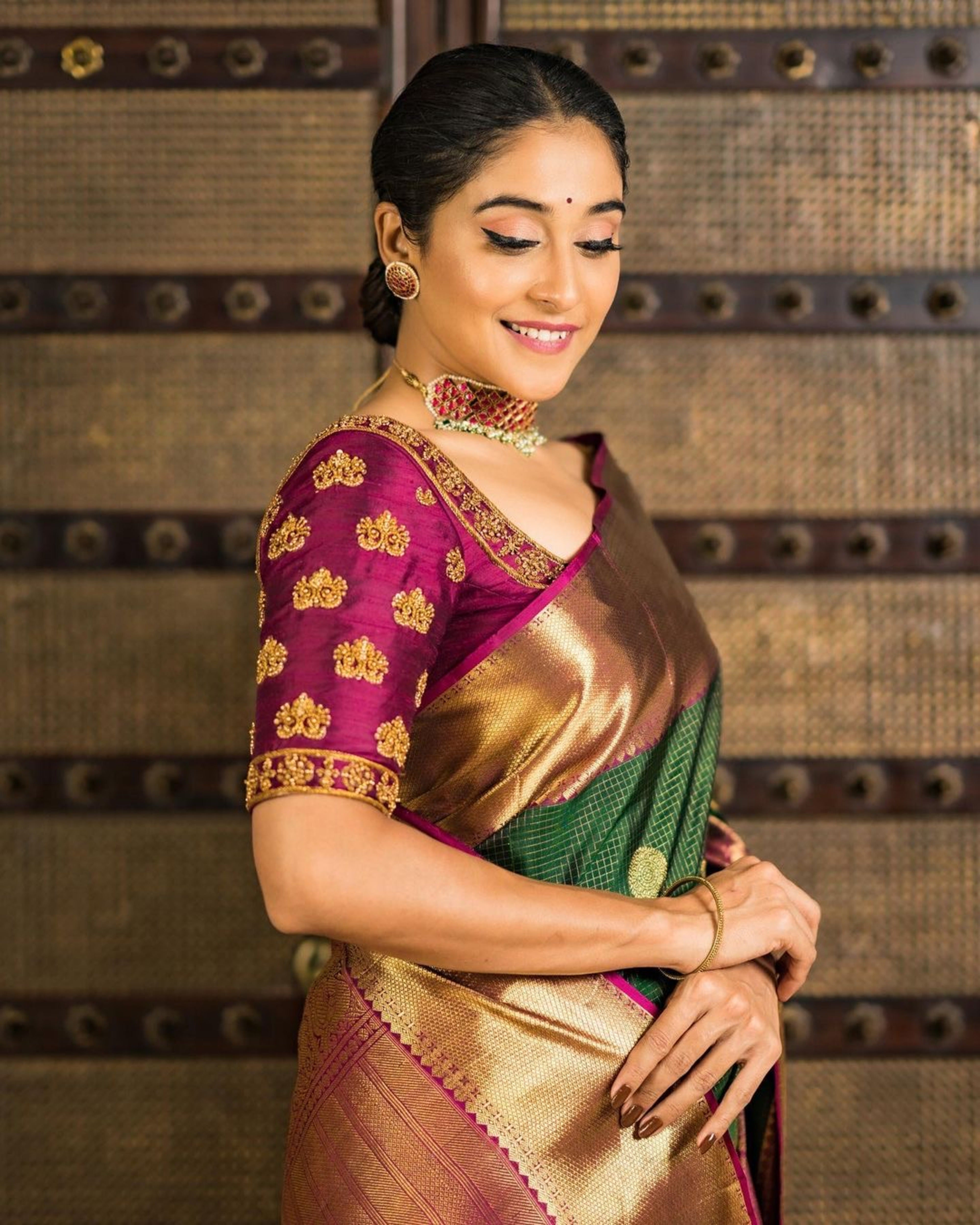 Actress Regina Cassandra in a wine red raw silk blouse designed by Archana Karthick. The blouse is handcrafted with zardozi work. She is looking to her right.