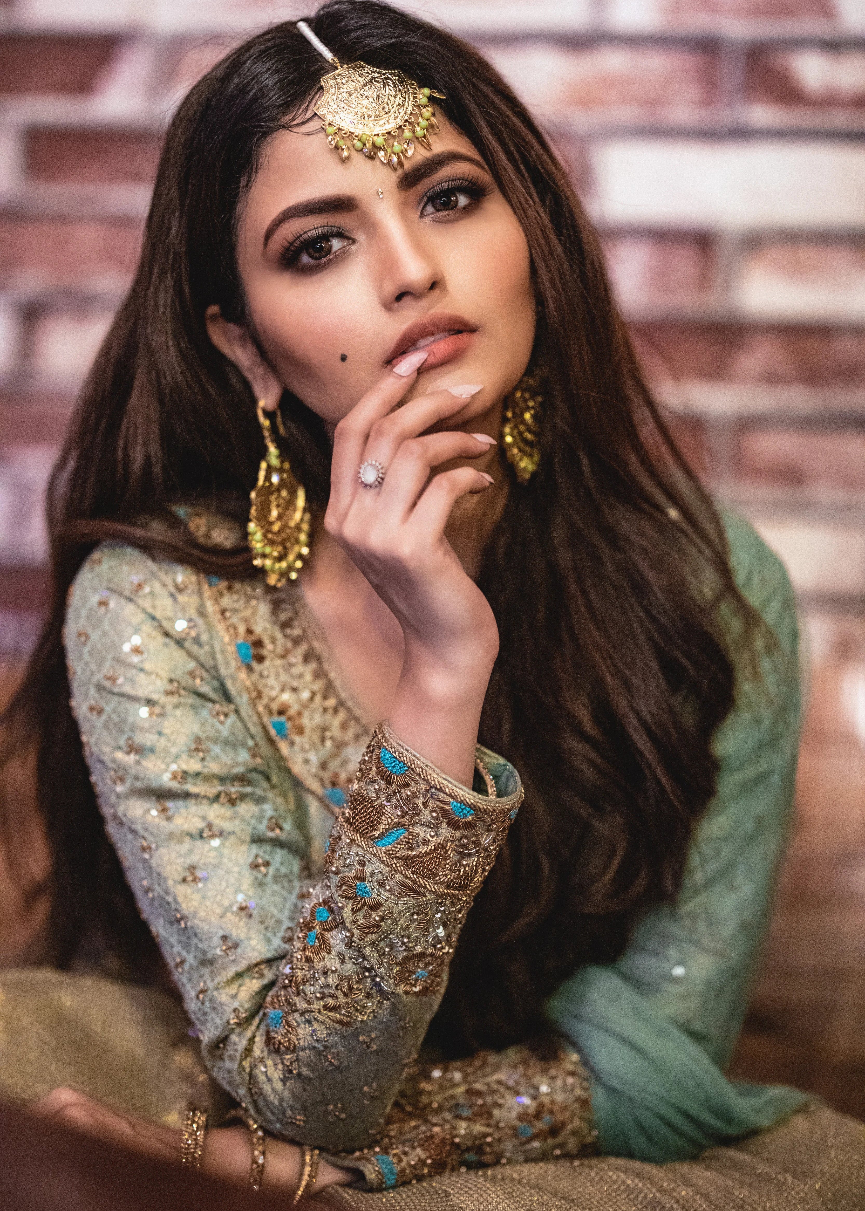 Actress Shirin Kanchwala in a handcrafted banaras (brocade) lehenga in shades of light sea green / pista blue / cyan designed by Archana Karthick looking at camera with finger on lips