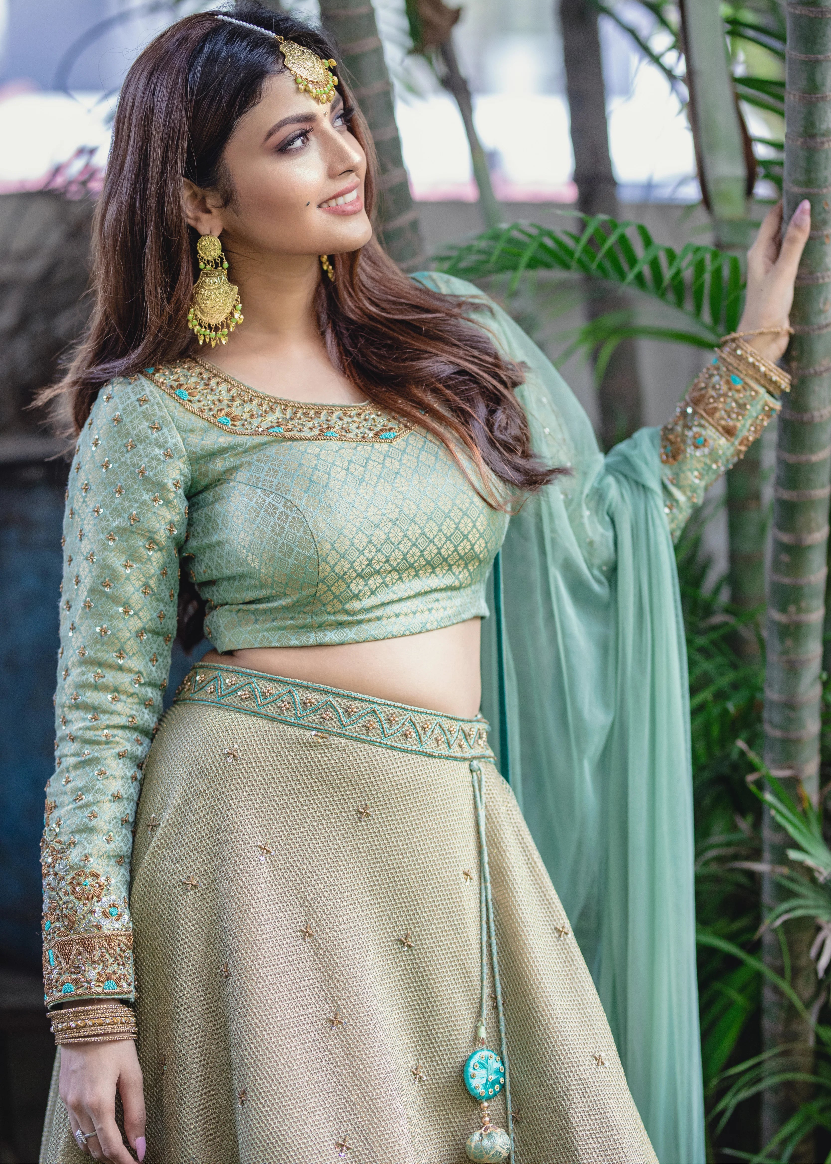 Actress Shirin Kanchwala in a handcrafted banaras (brocade) lehenga in shades of light sea green / pista blue / cyan designed by Archana Karthick posing for blouse front and sleeve design