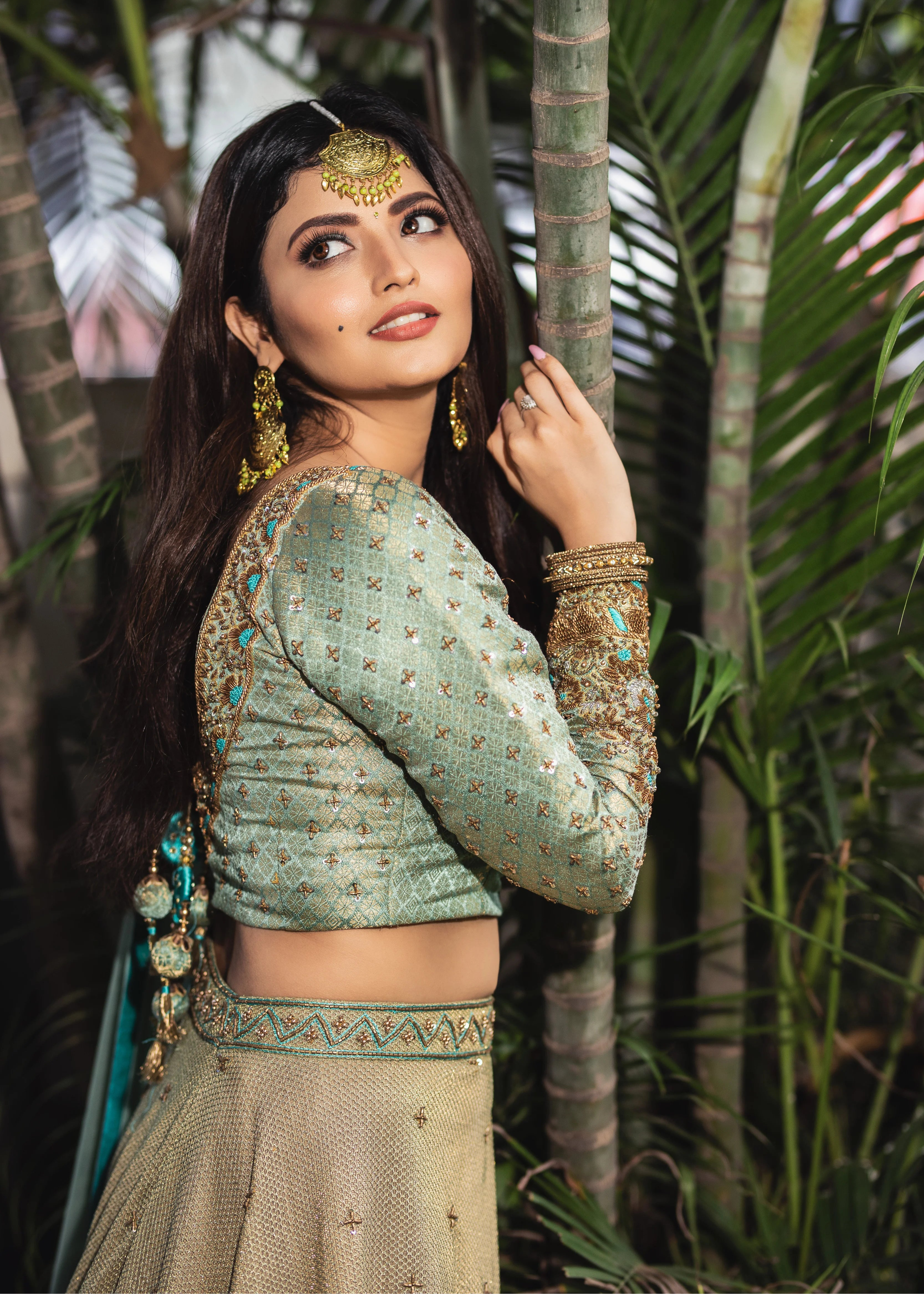 Actress Shirin Kanchwala in a handcrafted banaras (brocade) lehenga in shades of light sea green / pista blue / cyan designed by Archana Karthick posing for side profile