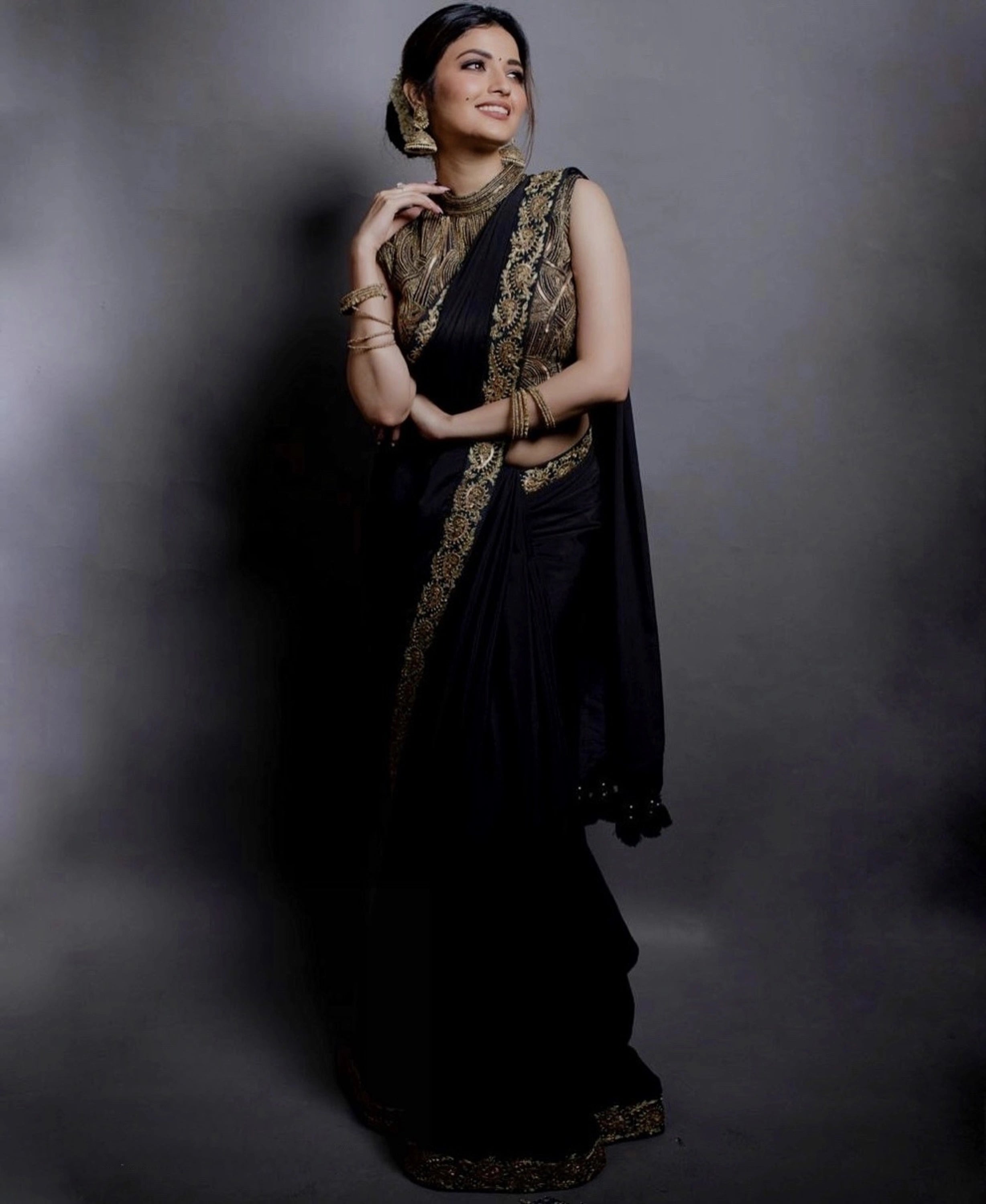 Actress Shirin Kanchwala smiling in a crepe silk black saree intricately handcrafted with zardozi, sequins and dori work by team Archana Karthick.