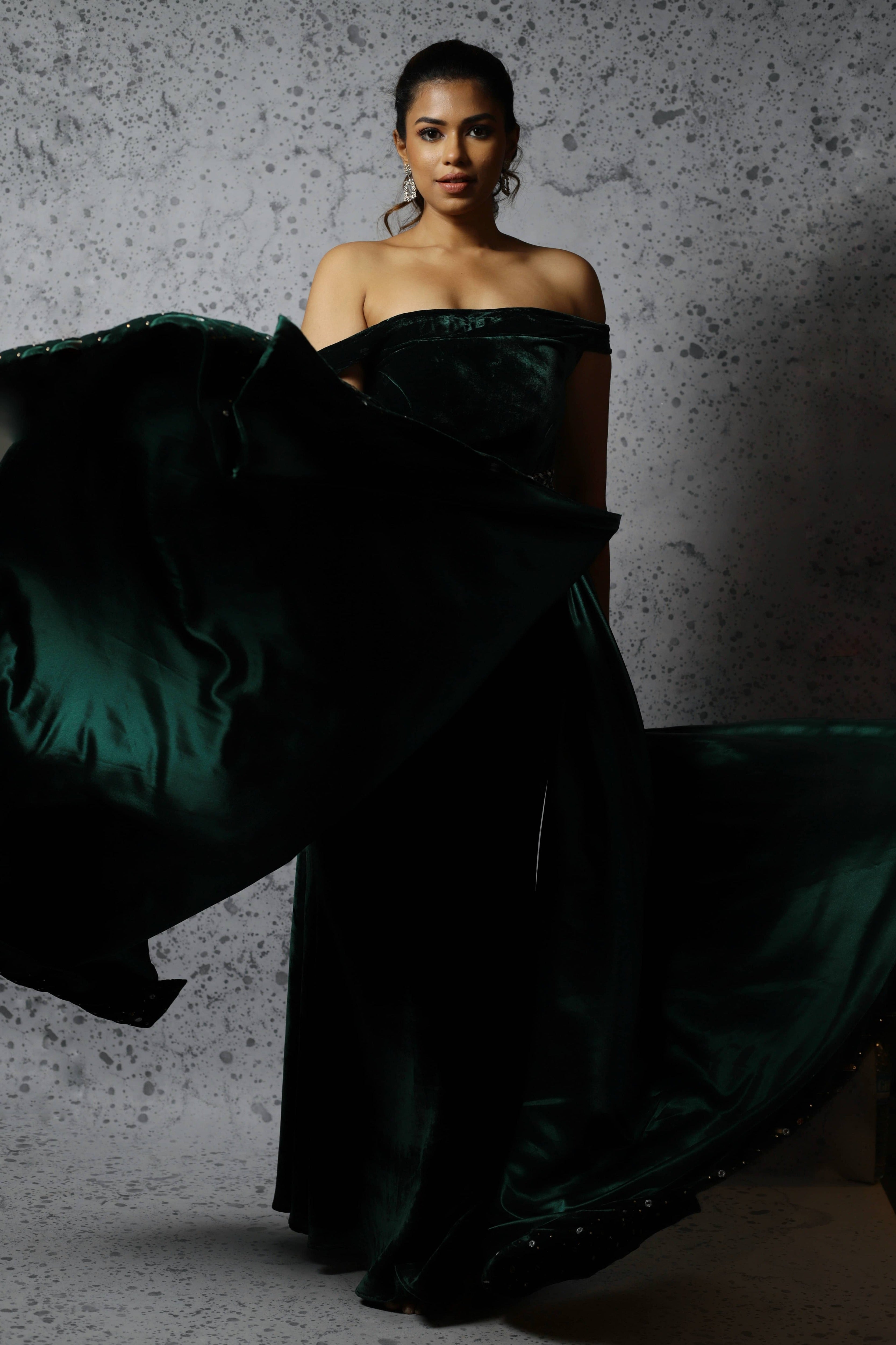 Actress Shrisha the niece of superstar actress Sridevi in a green velvet mermaid gown dress with detachable embellished belt and side trail. Full front profile twirl.