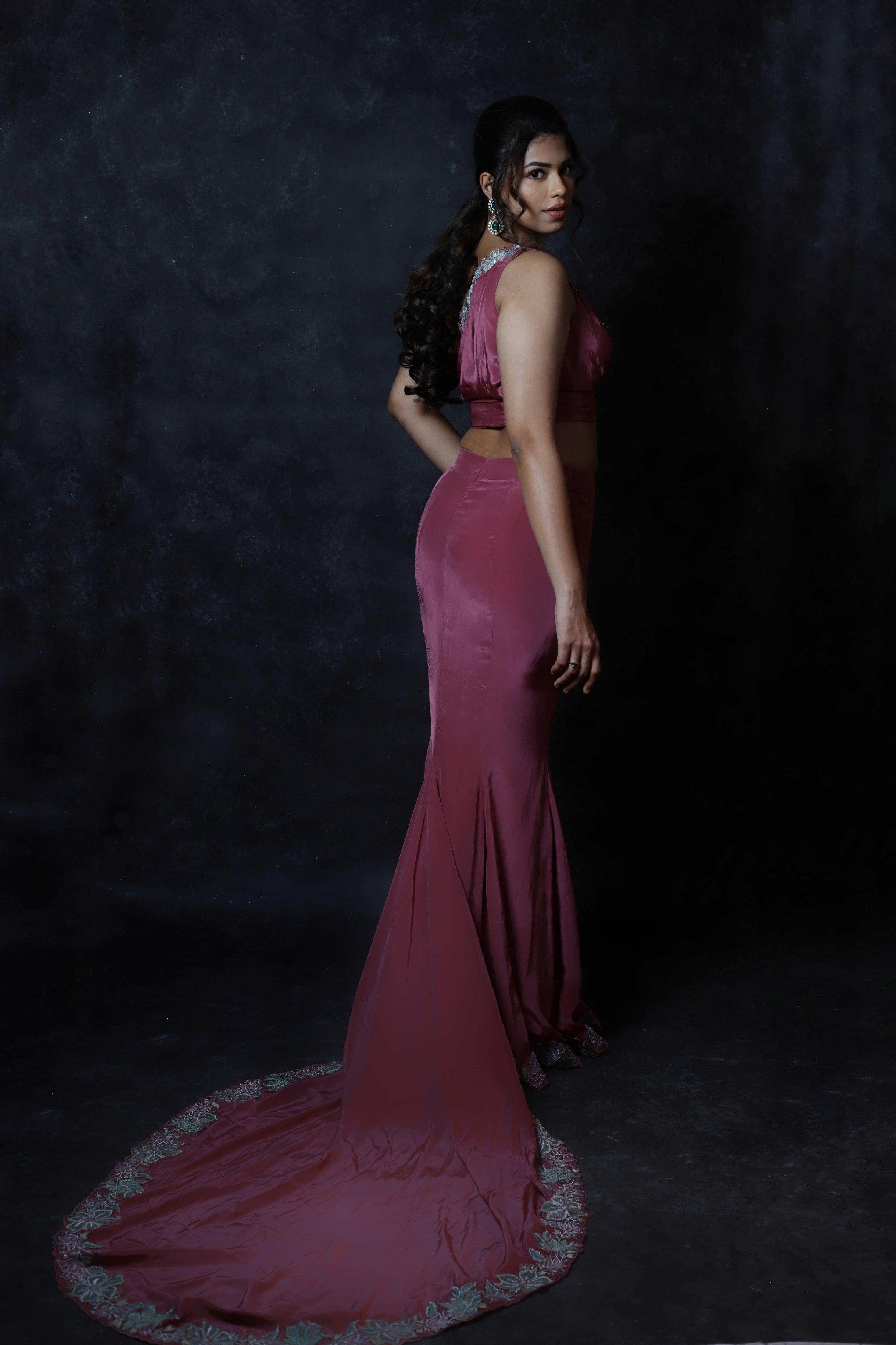 Actress Shrisha the niece of superstar actress Sridevi in a one shoulder mermaid fit dress with a trail. Full back design of pink mulberry silk outfit.