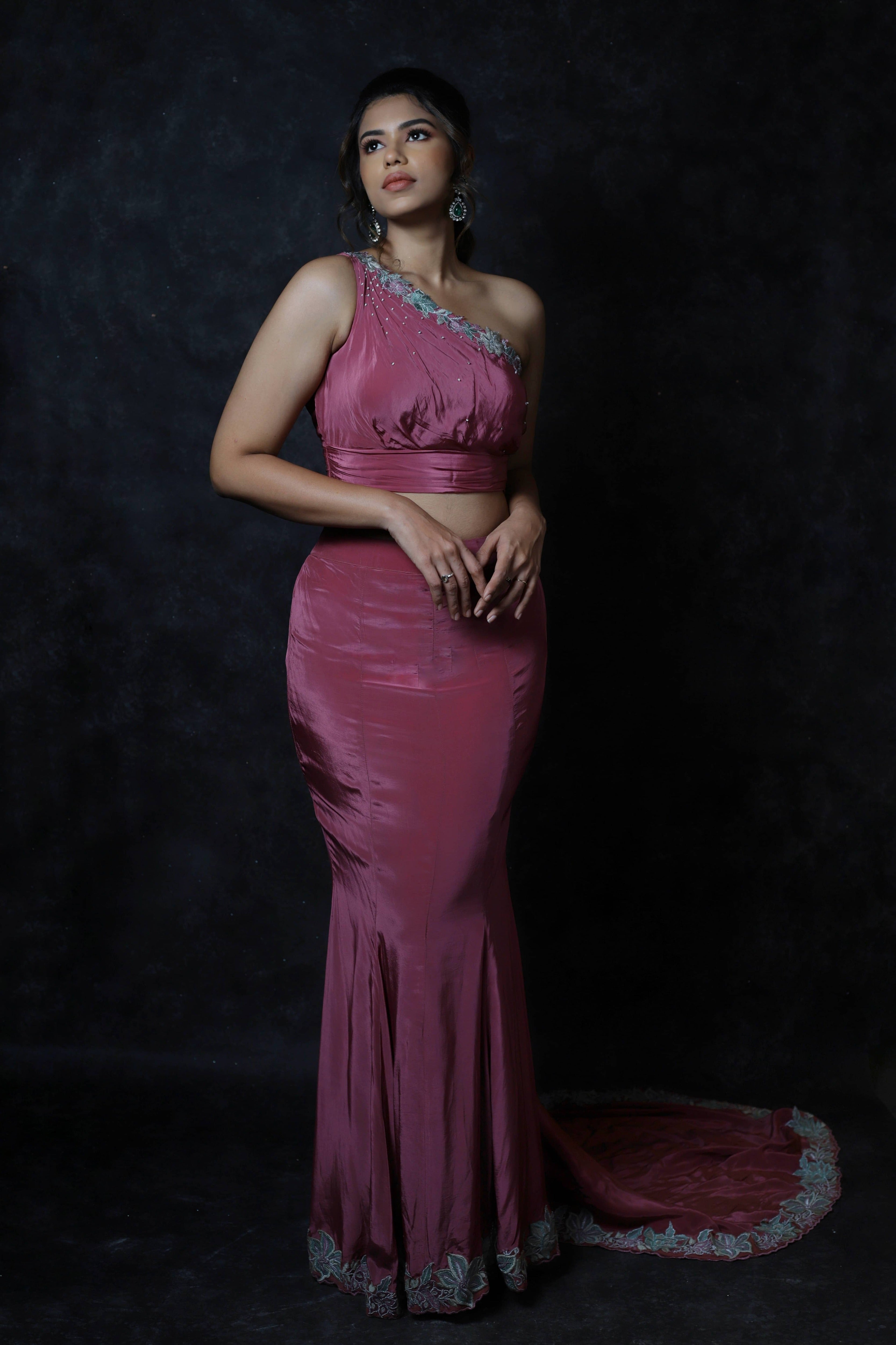 Actress Shrisha the niece of superstar actress Sridevi in a one shoulder mermaid fit dress with a trail. Pink mulberry silk outfit.