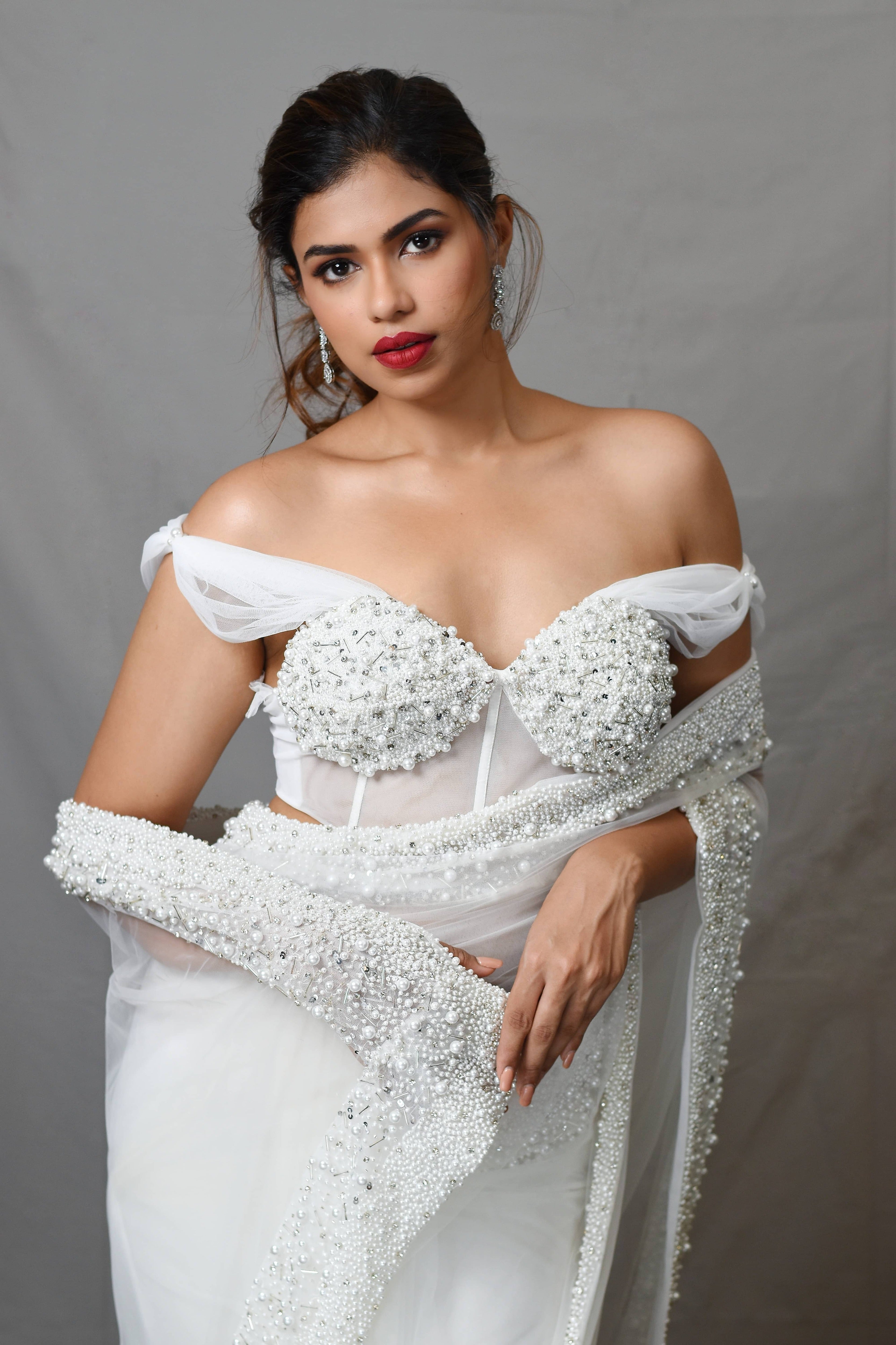 Actress Shrisha the niece of superstar actress Sridevi in a white net saree with embellished border and corset blouse with cowl sleeves. blouse and border detailing closeup