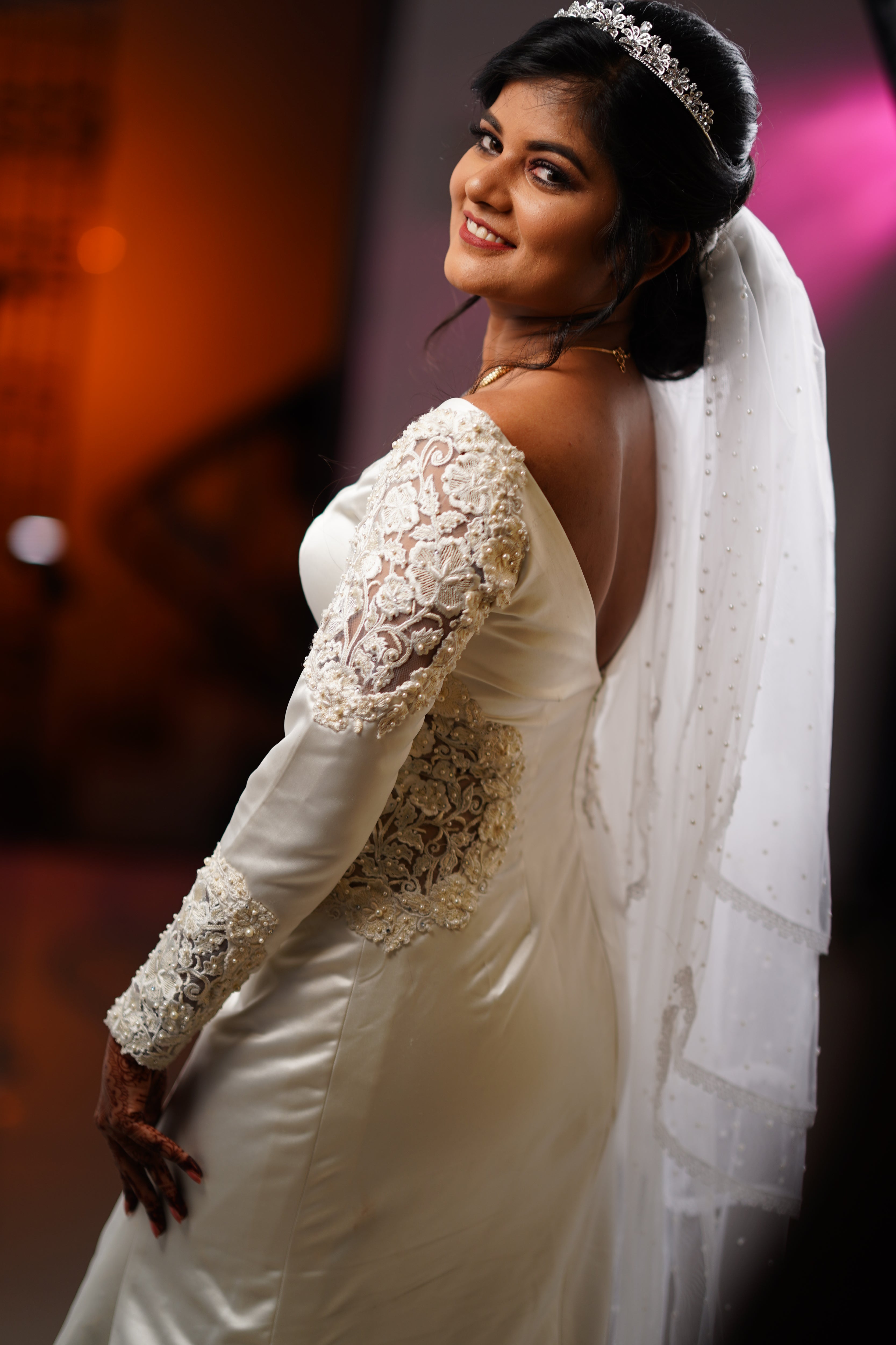 Adeal Josh posing in a white gown for her church wedding, handcrafted by team Archana Karthick.