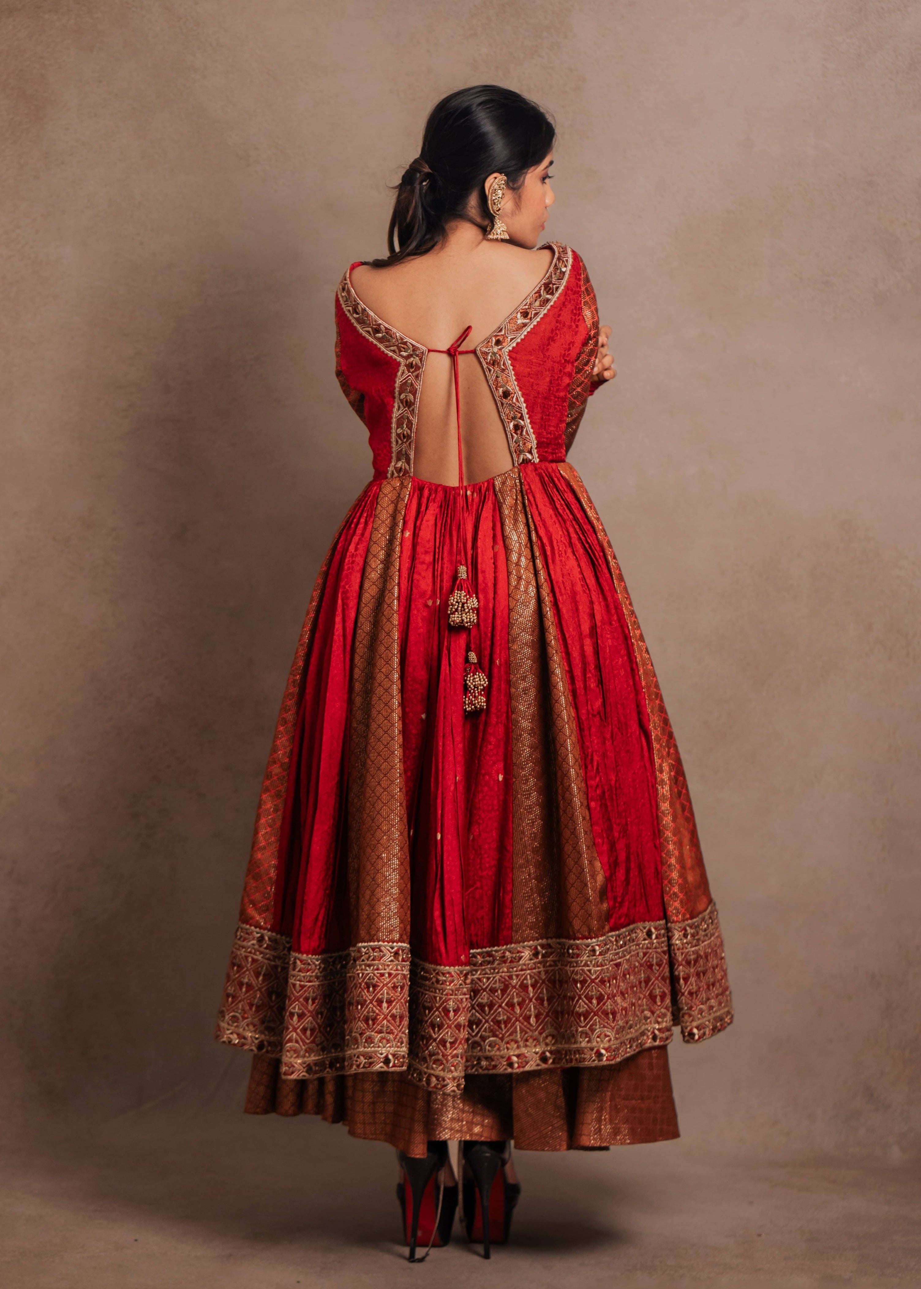 Back design details of a Red-orange angrakha anarkali in banarasi tissue and silk paired with a sharara pant and a delicate tissue dupatta by team Archana Karthick