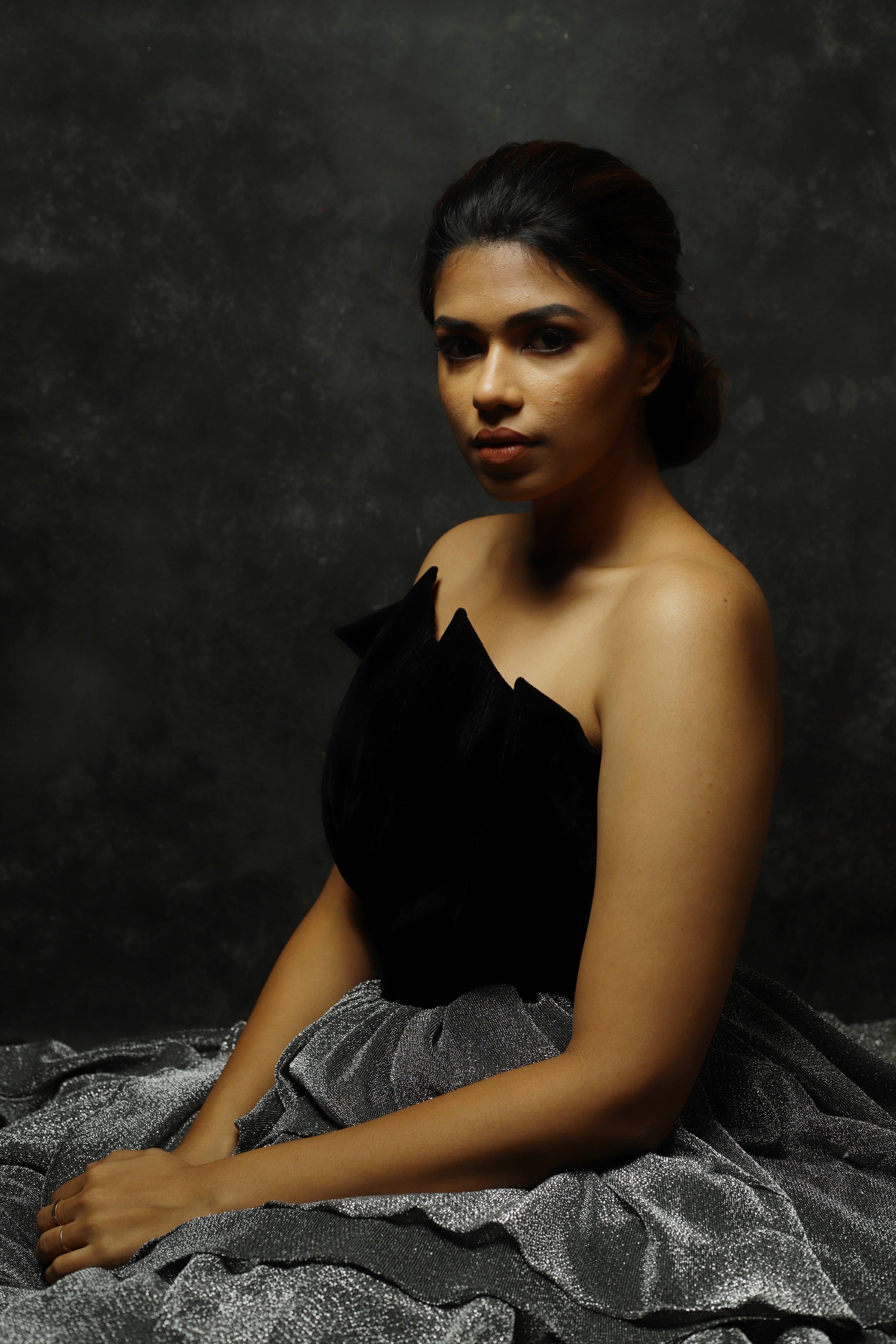 Black Velvet corset yoke with layered silver skirt gown designed by Archana Karthick. Actress Shrisha Closeup shot upper half profile.
