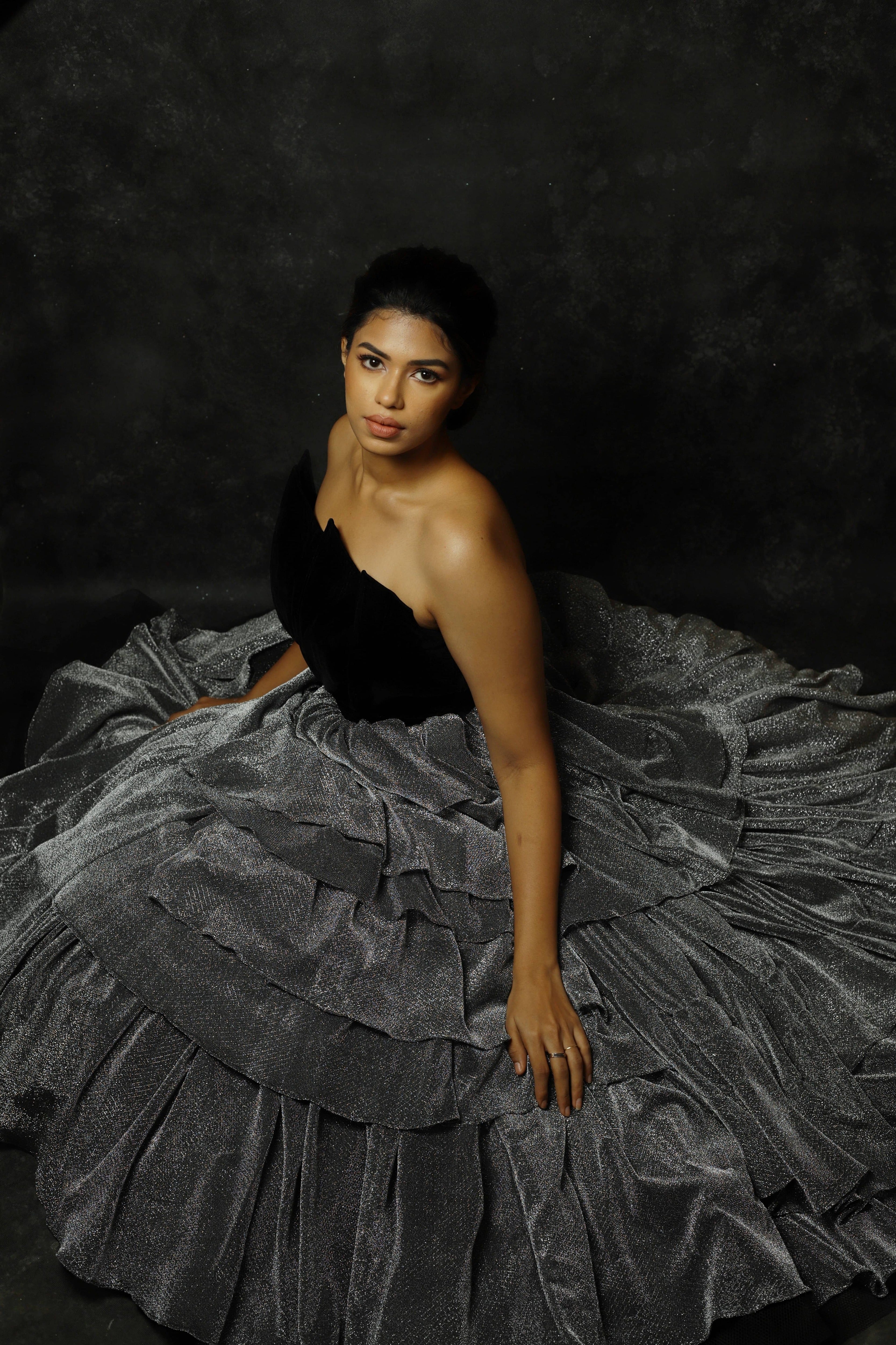 Black Velvet corset yoke with layered silver skirt gown designed by Archana Karthick. Actress Shrisha Full flare of the outfit.