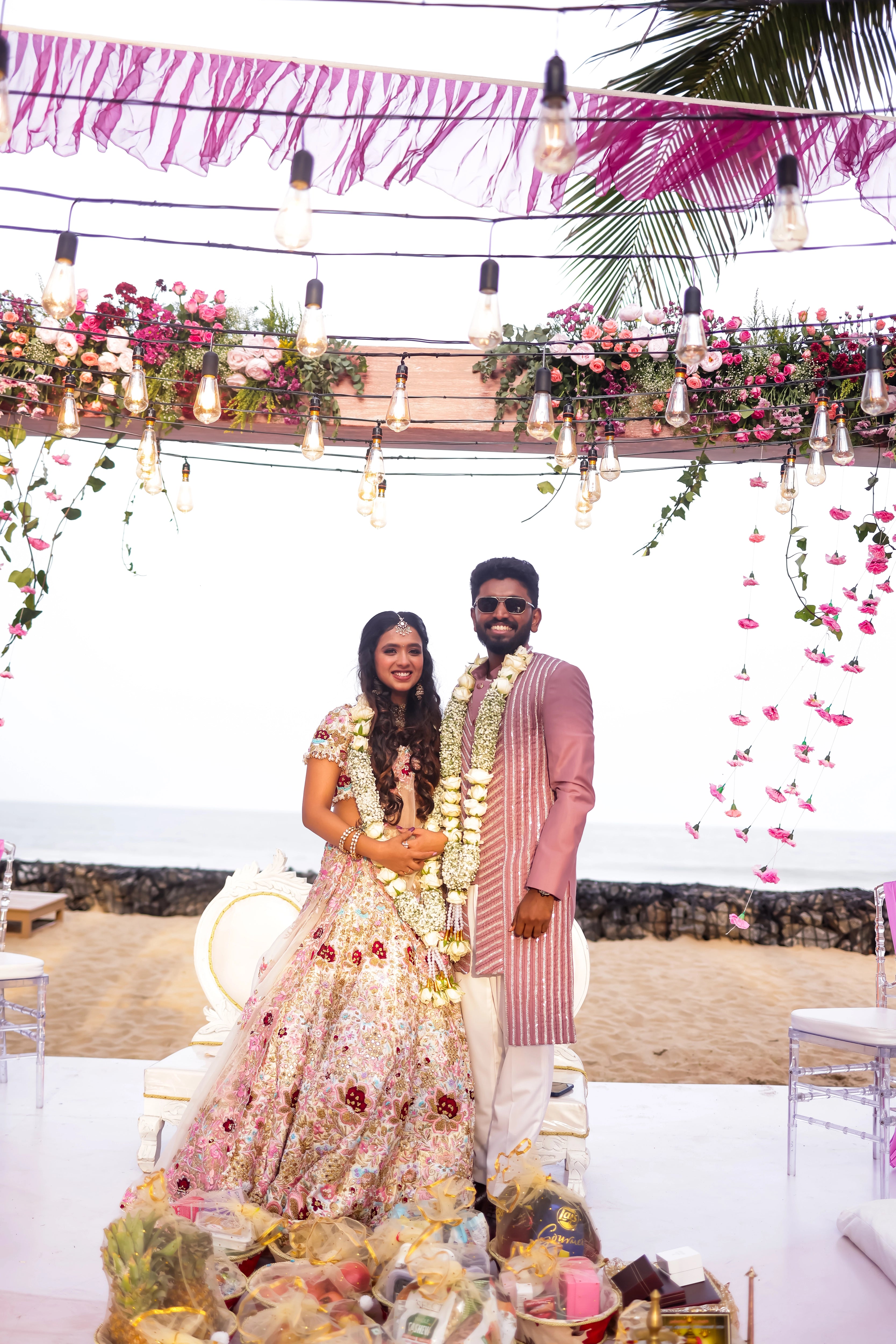 Bride Aarthi Rajagopal from USA posing with groom again in a concept ivory lehenga, intricately handcrafted with resham knot work, crystals, cutdana, pearls, sequins and zardozi.