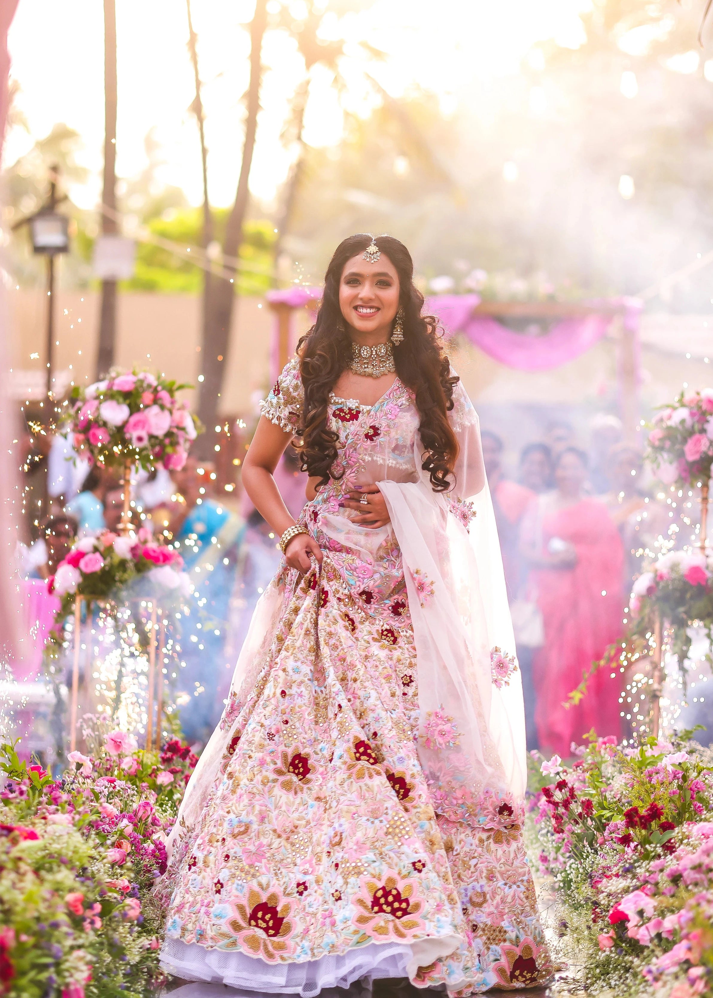 Bride Aarthi Rajagopal from USA smiling at groom again in a concept ivory lehenga, intricately handcrafted with resham knot work, crystals, cutdana, pearls, sequins and zardozi.