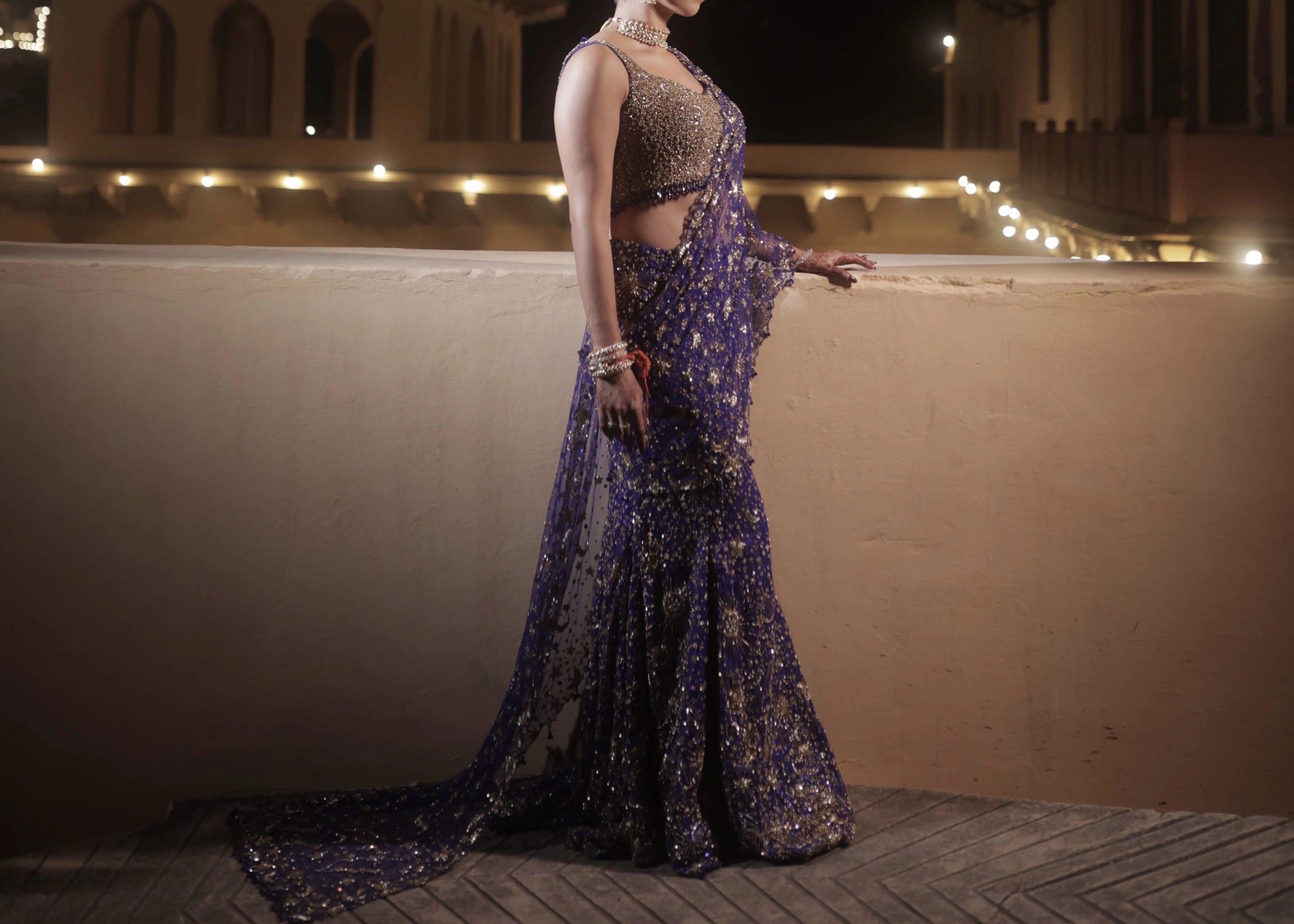Bride Aashi Pal posing for photo in a midnight blue tulle draped lehenga, handcrafted by team Archana Karthick.