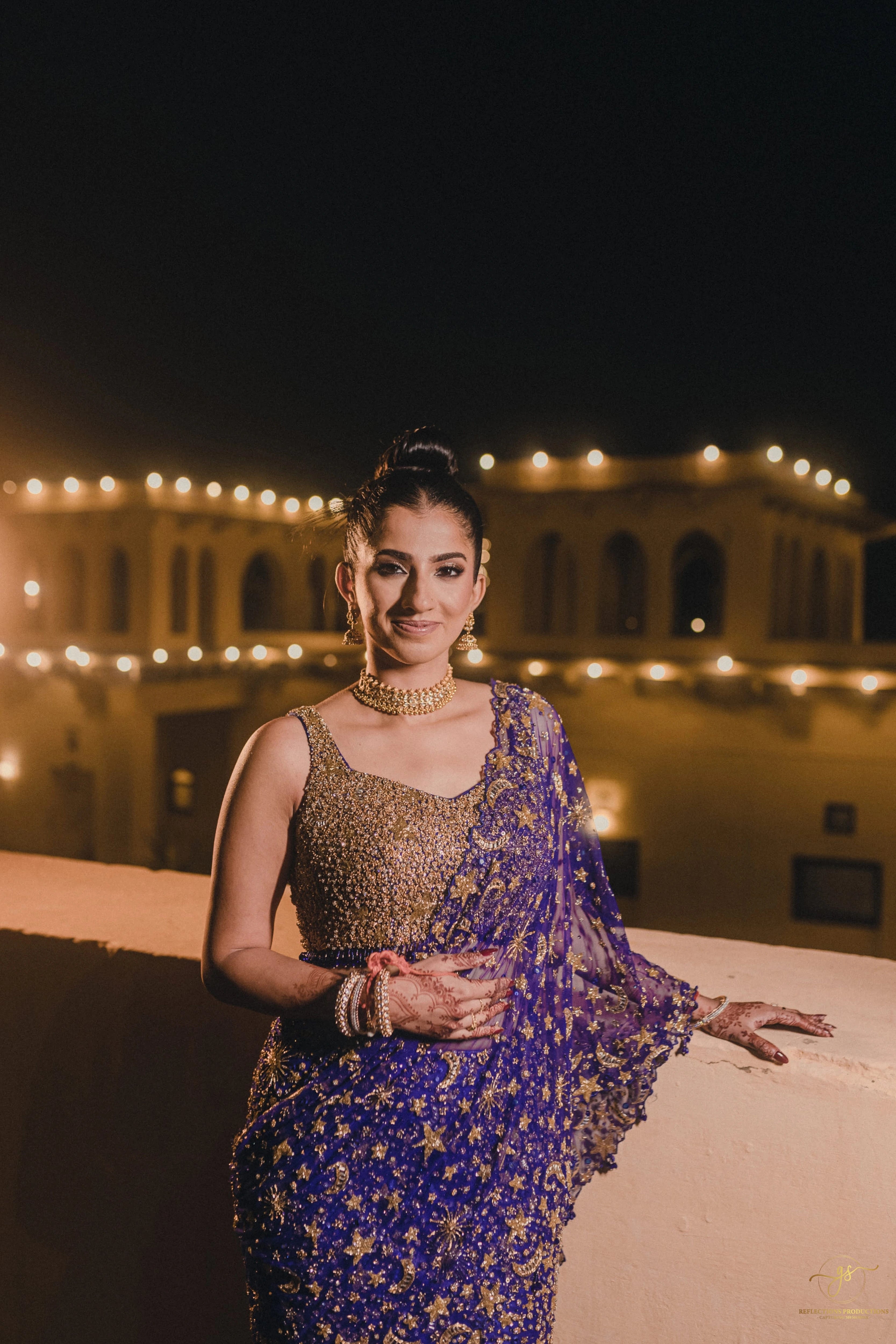 Bride Aashi Pal posing for photoshoot in a midnight blue tulle draped lehenga, handcrafted by team Archana Karthick.