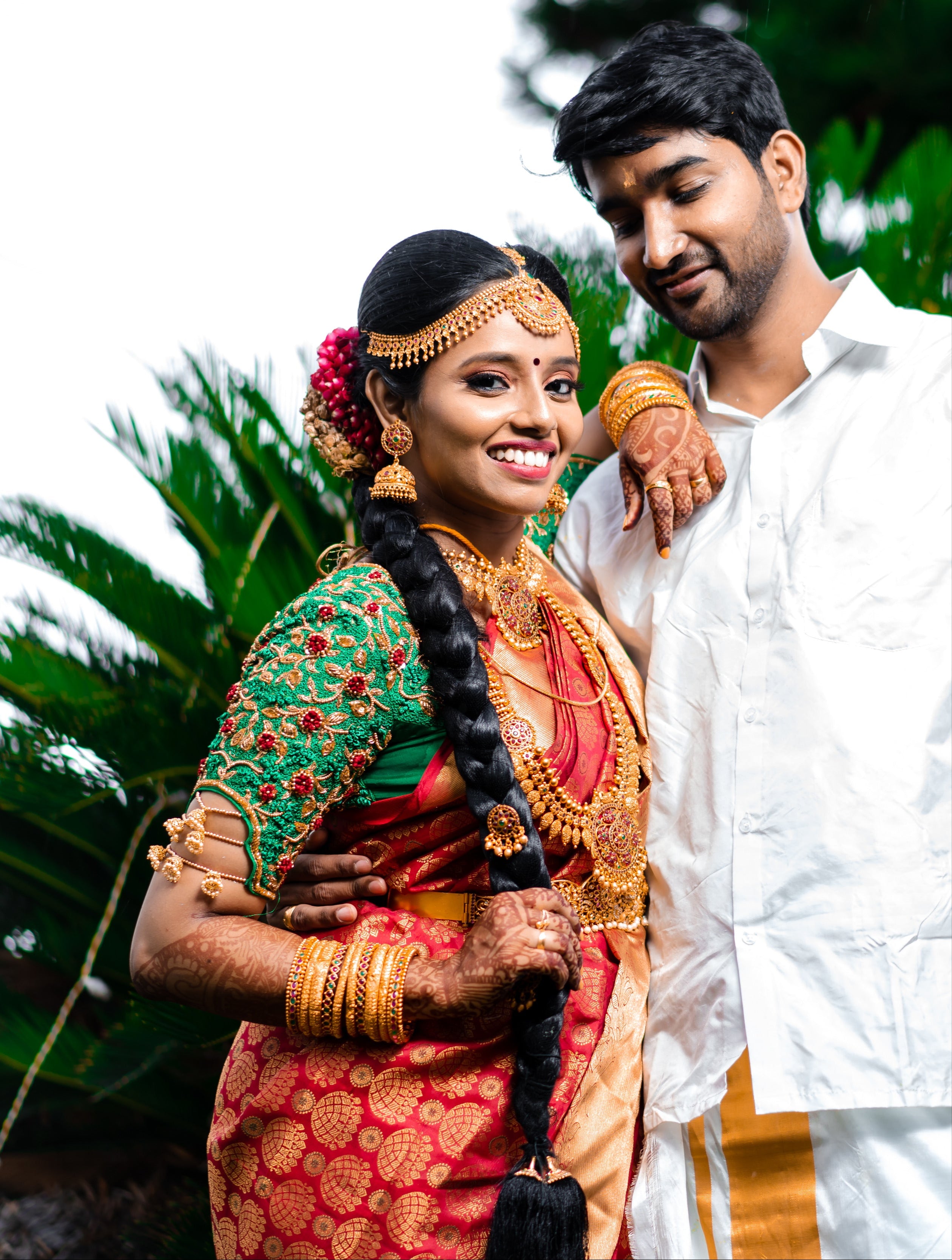 Bride Abhinaya in a handcrafted green raw silk blouse designed by Archana Karthick. Bride is posing with the groom.