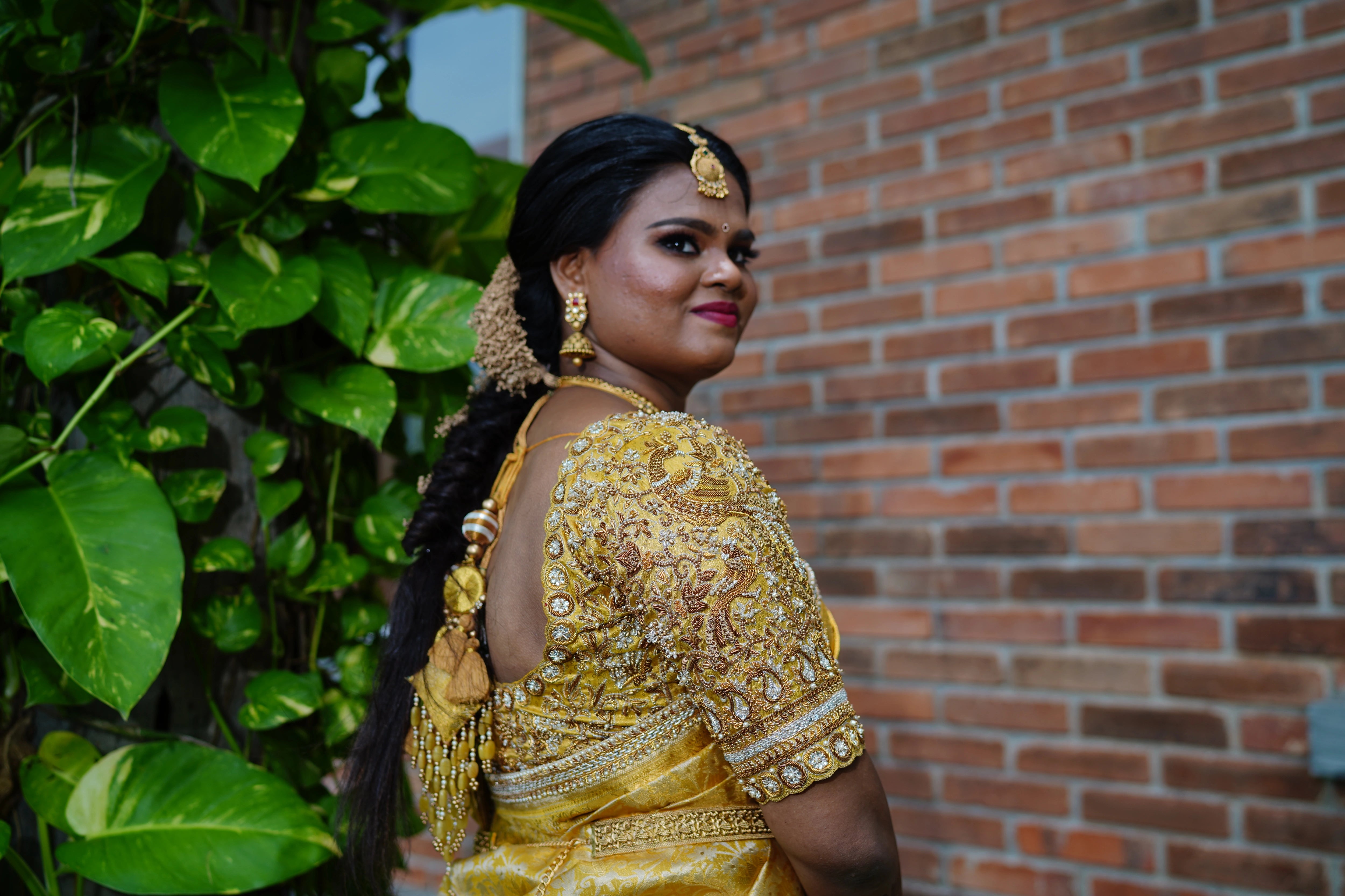 Bride Abinaya posing in a gold concept silk blouse and saree border, intricately handcrafted by team Archana Karthick.