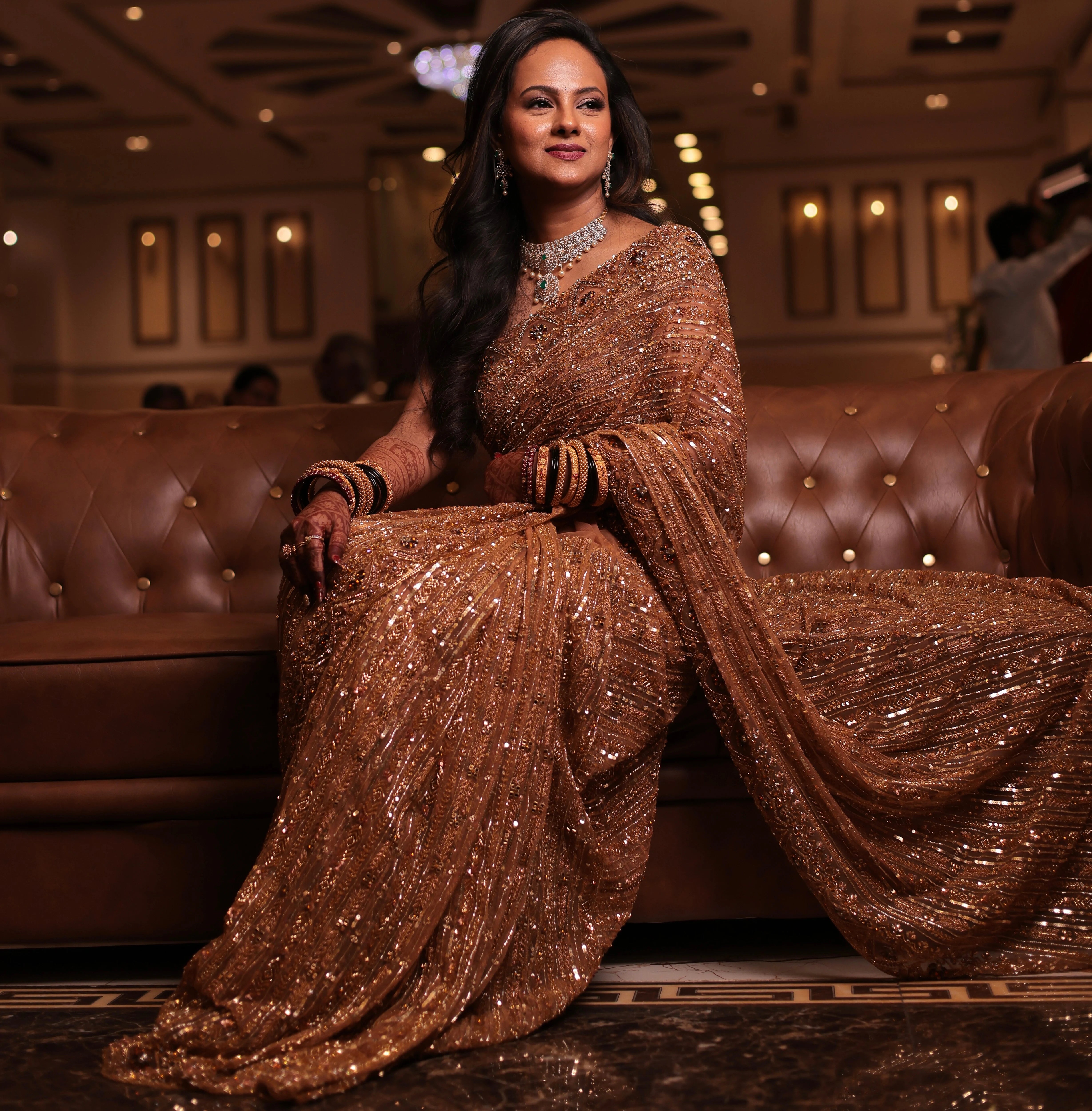 Bride Aishwarya from USA, posing in a golden tulle saree handcrafted by team Archana Karthick.