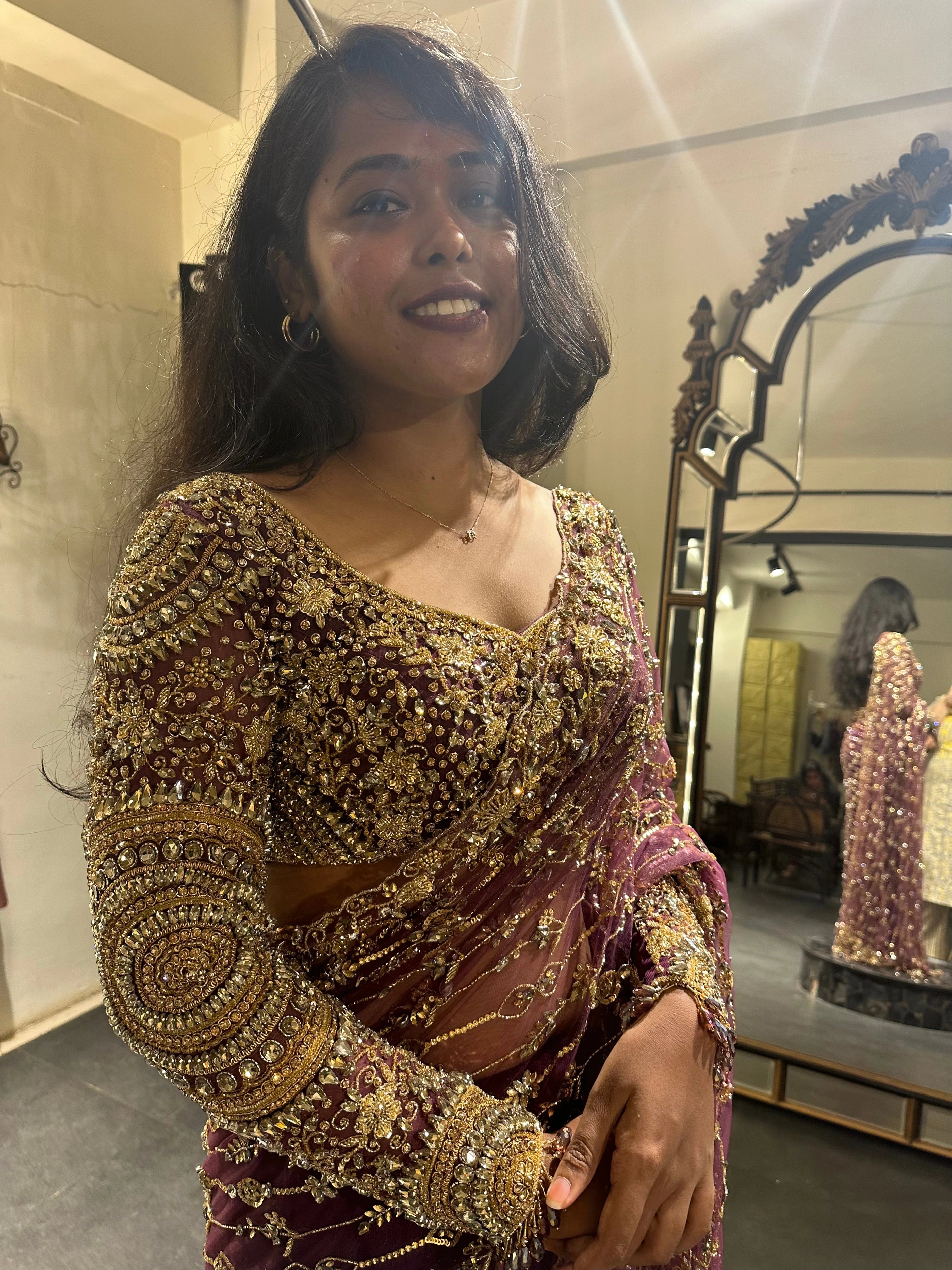 Bride Akalya smiling during fittings in a wine red tulle saree handcrafted by team Archana Karthick.