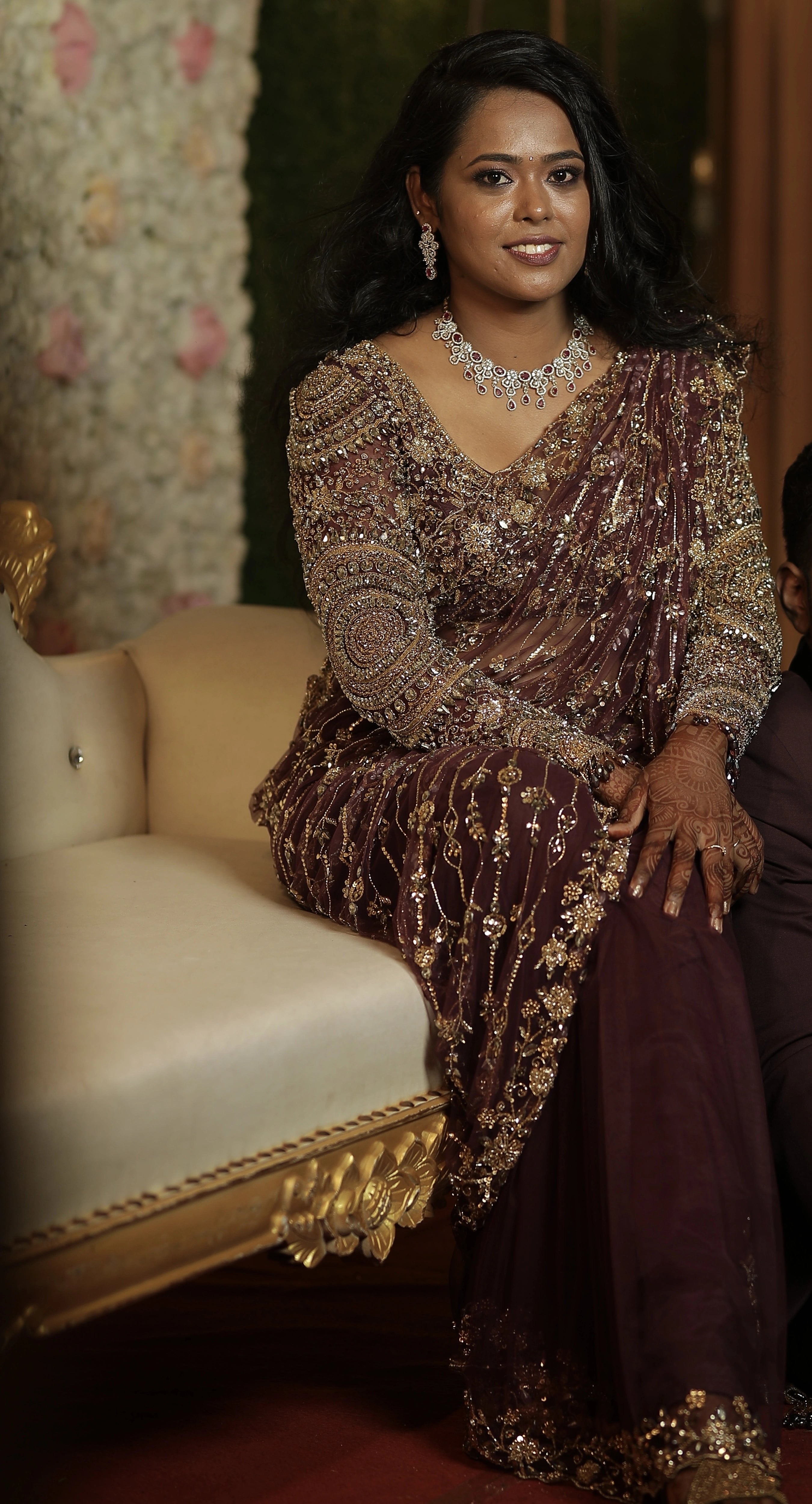 Bride Akalya smiling in a wine red tulle saree handcrafted by team Archana Karthick.
