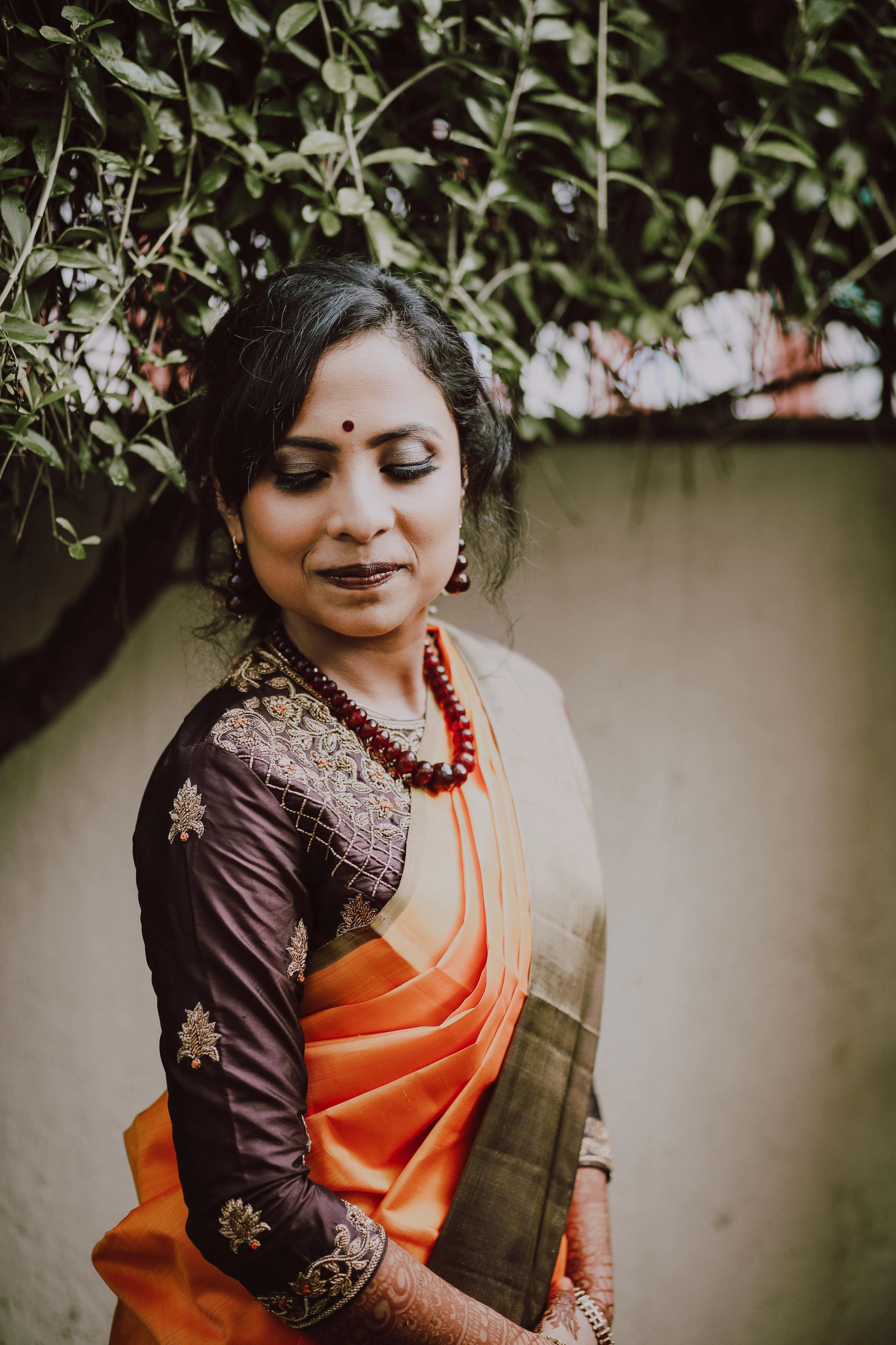 Bride Akshaya from USA posing in a brown silk blouse handcrafted intricately with beads, cutdana and resham by team Archana Karthick.