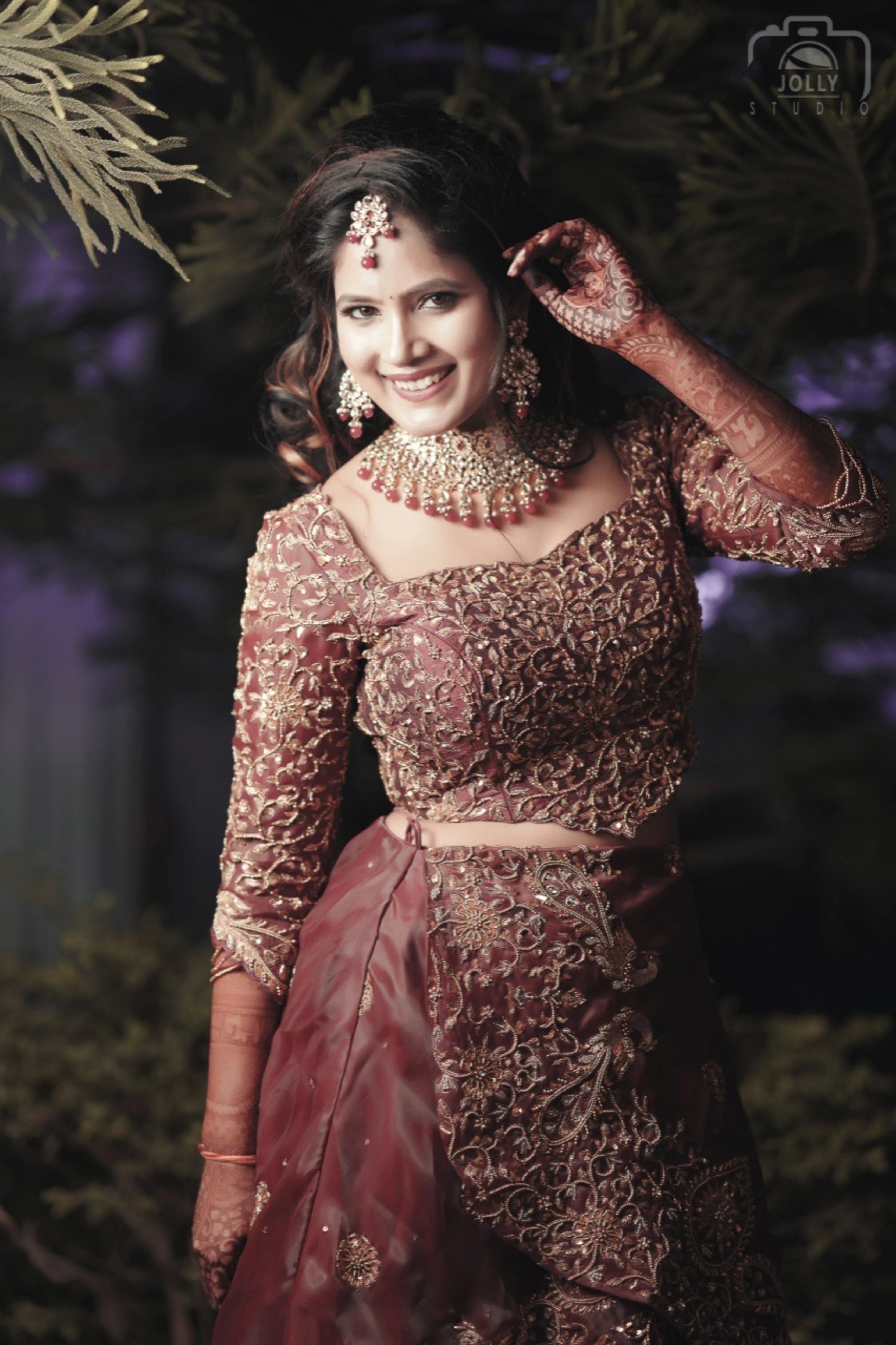 Bride Ankita Singh posing in a red lehenga intricatelty handcrafted with resham, cutdana, zari and beads by team Archana Karthick.