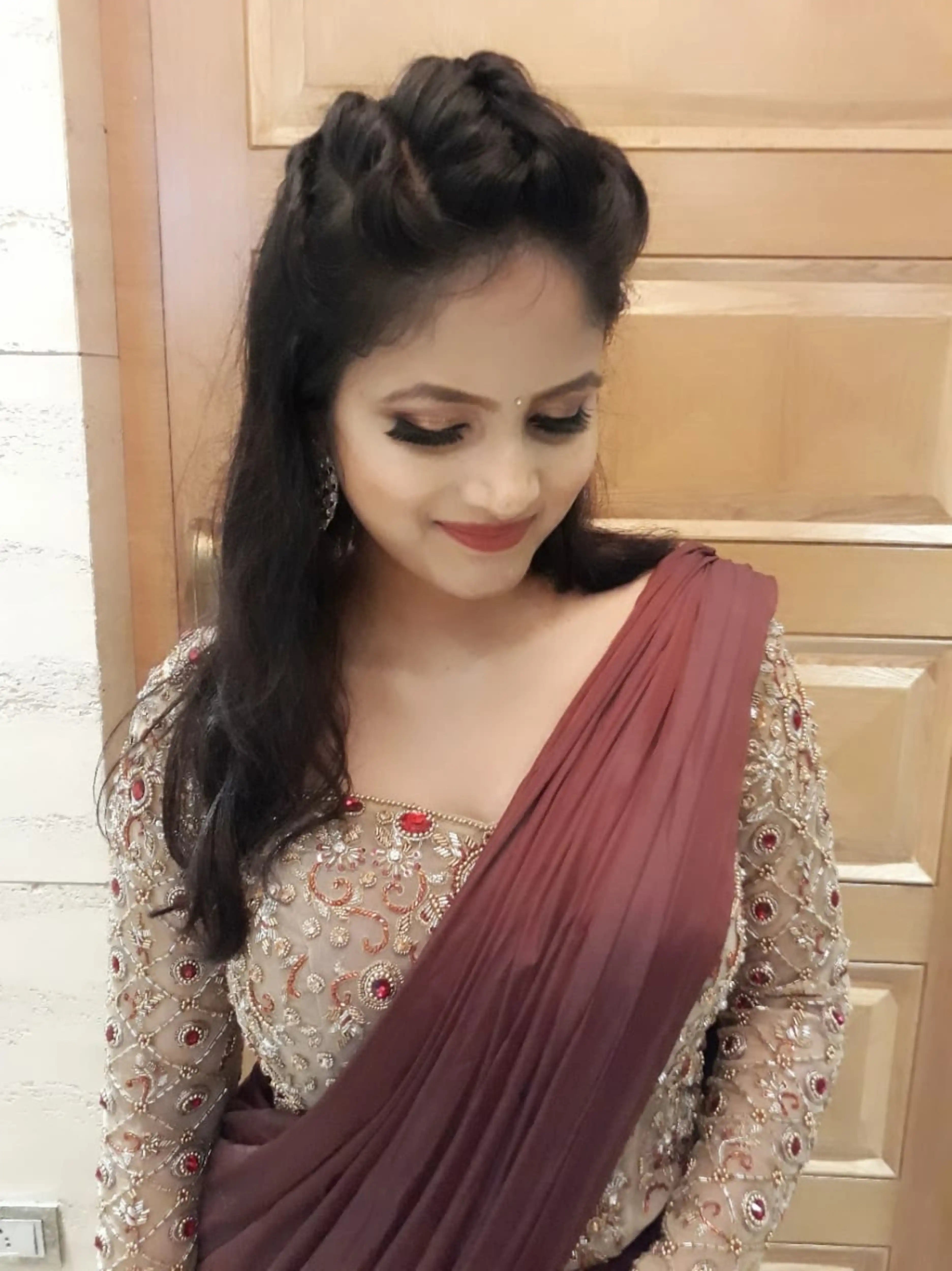 Bride Ankita smiling in a champagne gold tulle blouse and brown mermaid saree handcrafted by team Archana Karthick.