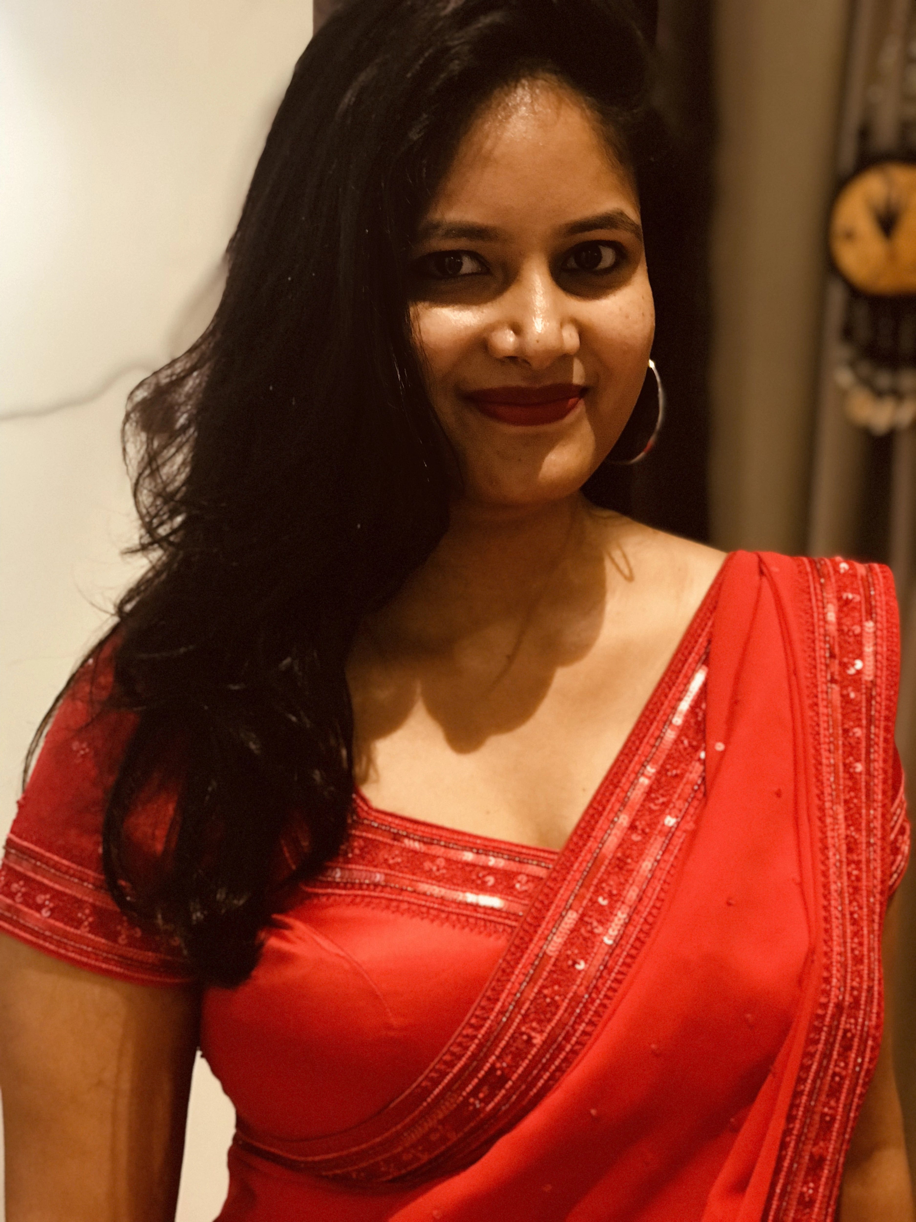 Bride Ankita smiling in a red georgette saree and blouse handcrafted by team Archana Karthick.