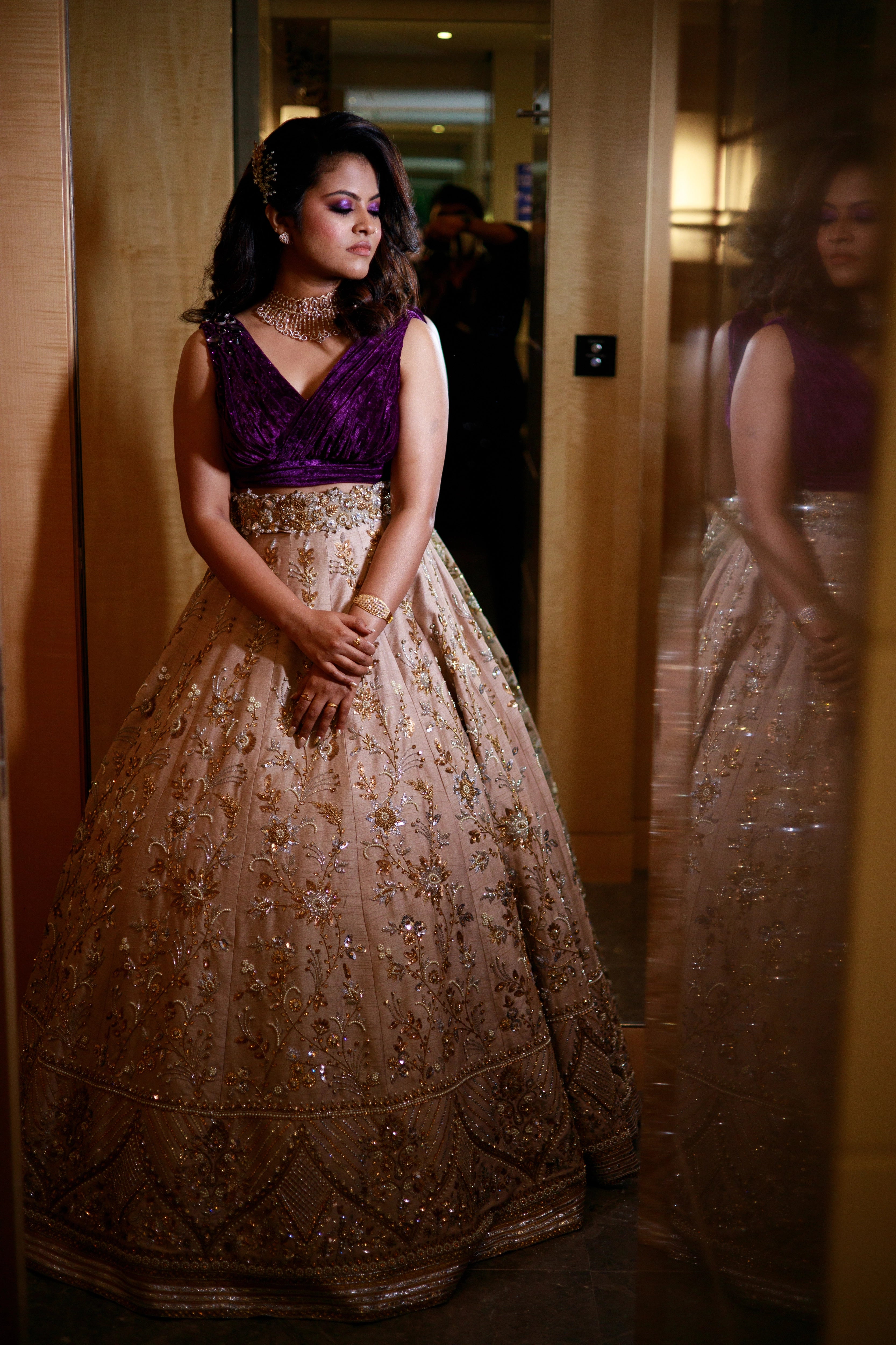 Bride Anu from Kerala posing in a purple & beige lehenga, handcrafted by team Archana Karthick.