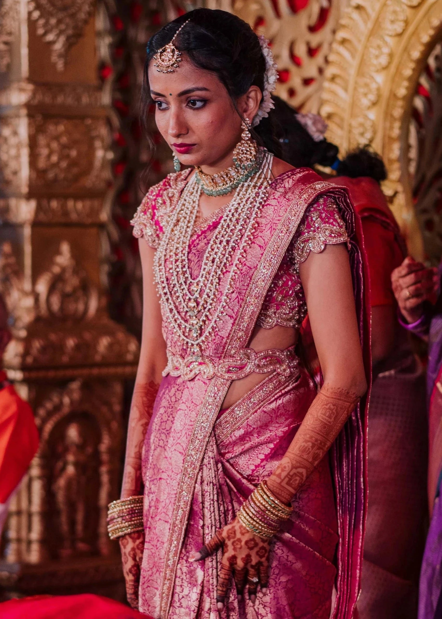 Bride Anusha K during ritual in a pink concept raw silk blouse, belt and saree border, handcrafted with zardosi, beads, kundan, cutdana, pearls and sequins by team Archana Karthick