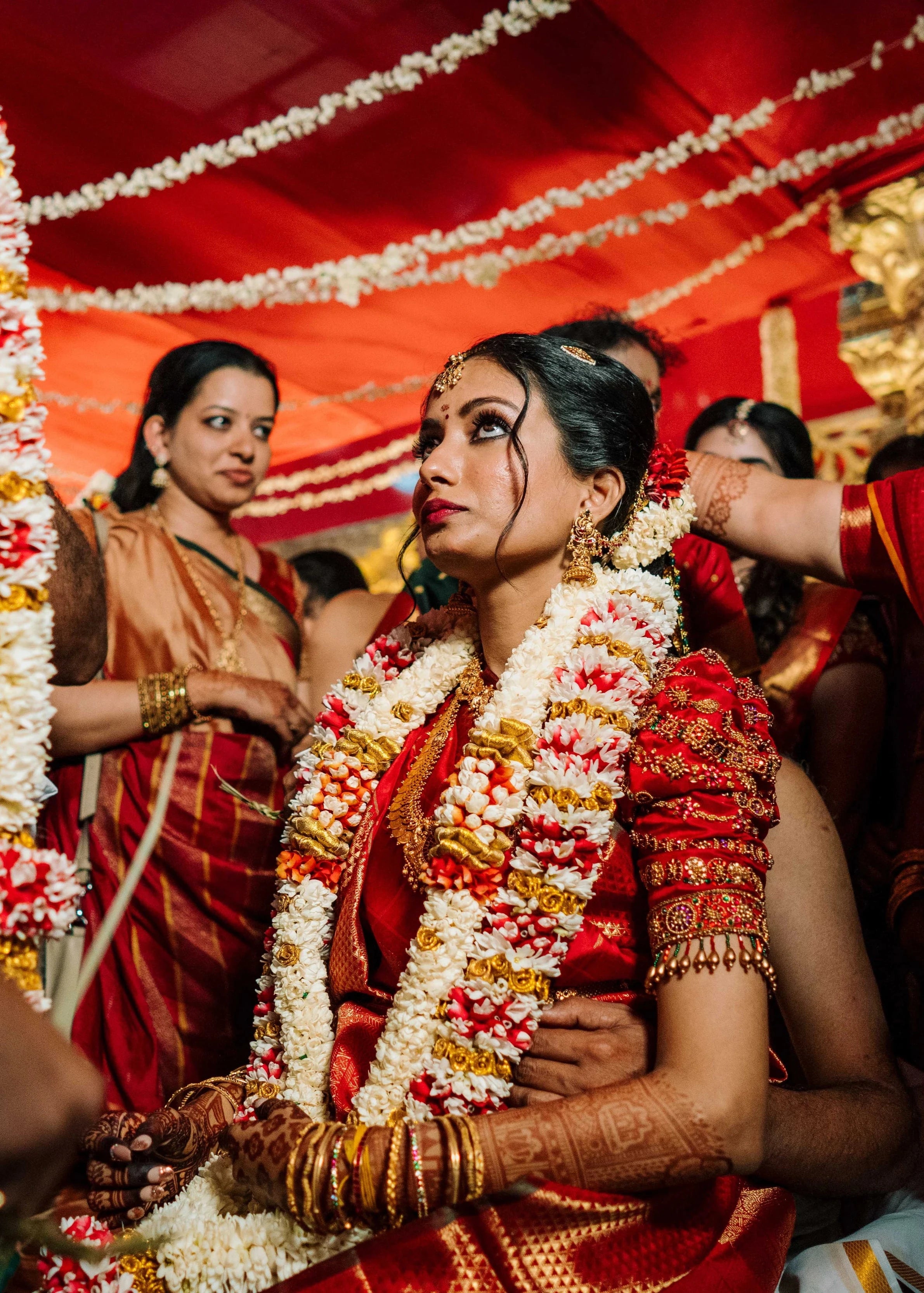 Bride Anusha K in a red concept silk puff sleeved blouse, intricately handcrafted with zardosi, beads, kundan, and kemp stones by team Archana Karthick.