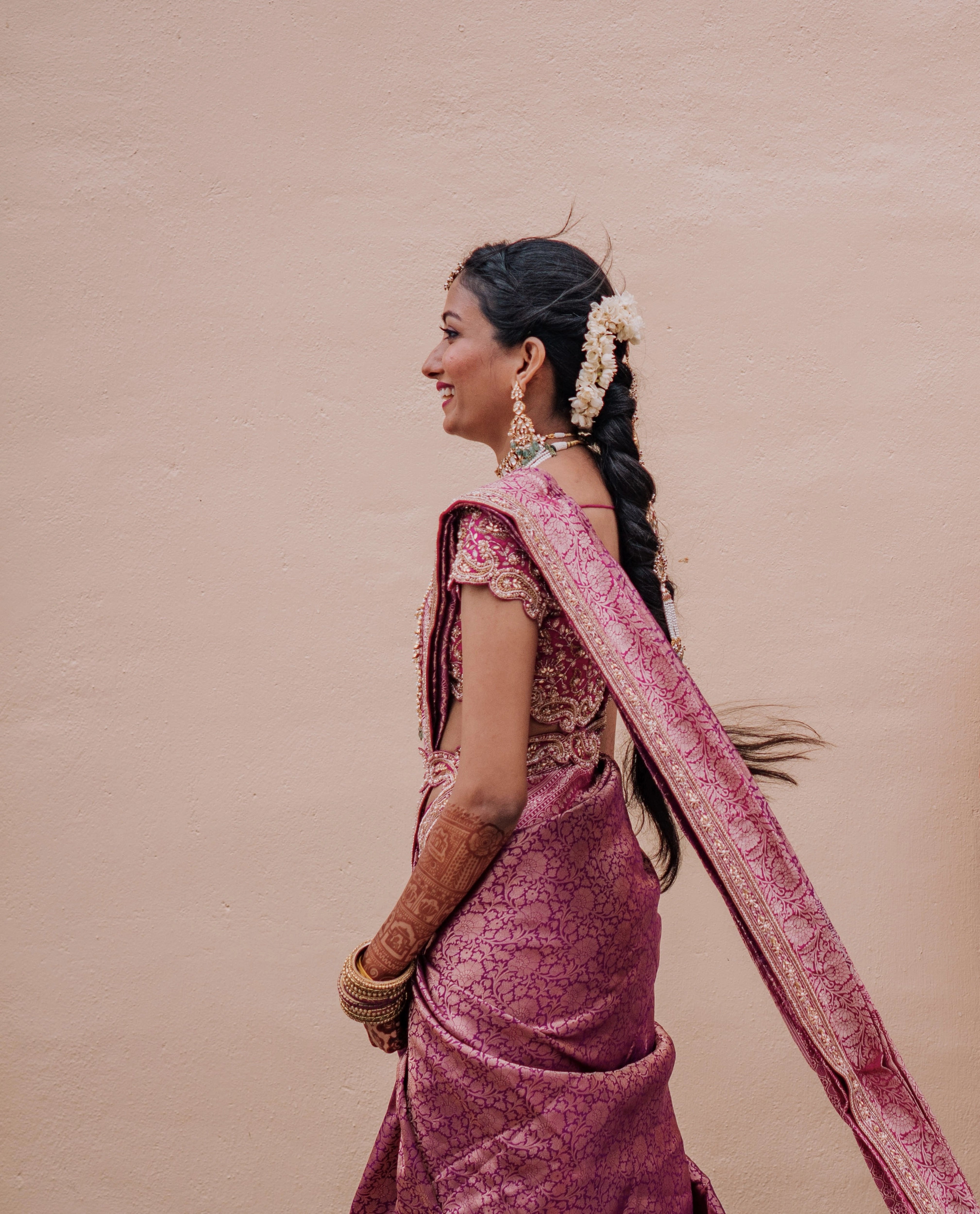 Bride Anusha K laughing in a pink concept raw silk blouse, belt and saree border, handcrafted with zardosi, beads, kundan, cutdana, pearls and sequins by team Archana Karthick