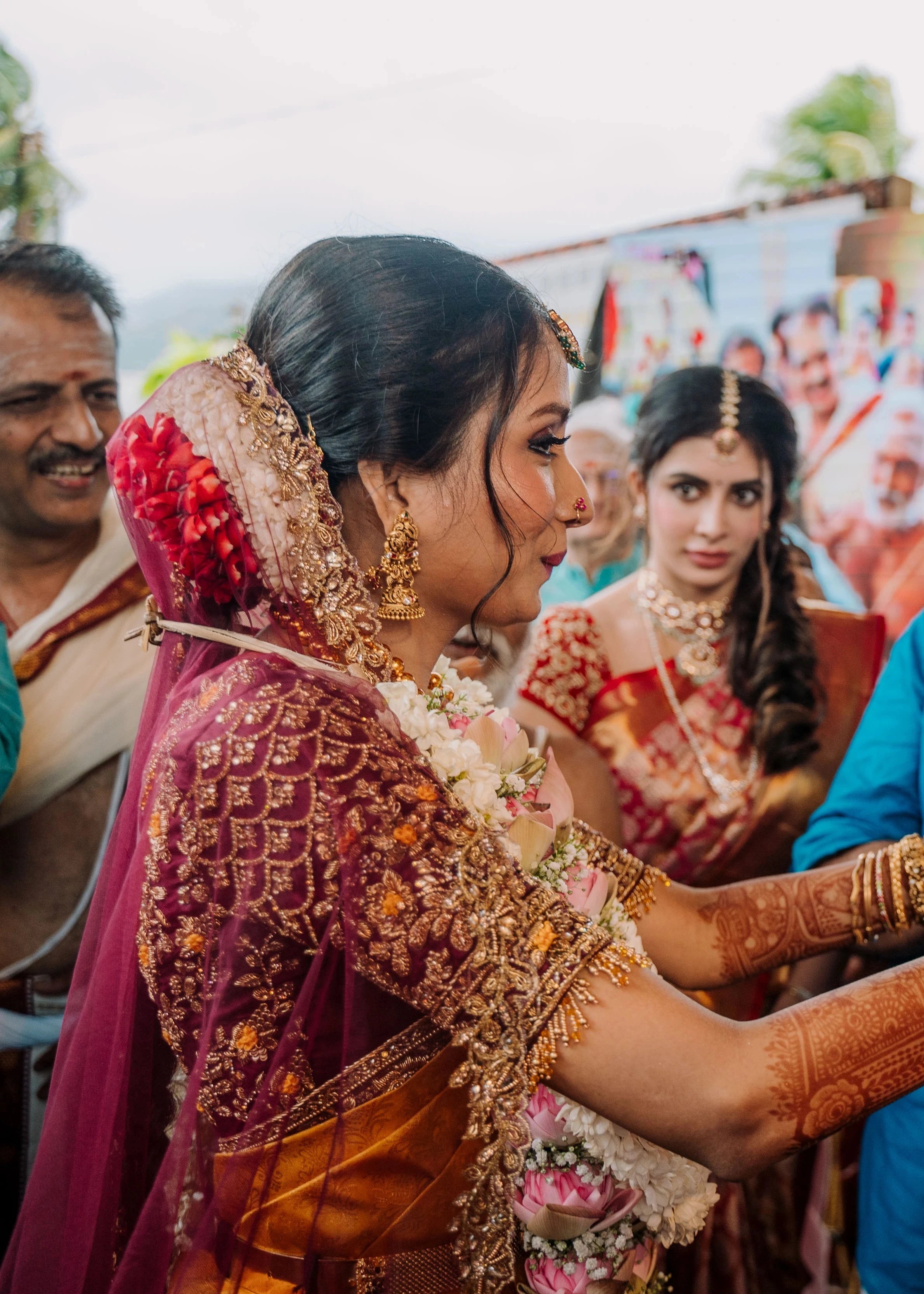 Bride Anusha K with garland in a wine red concept raw silk blouse, veil and saree border, handcrafted with zardosi, beads, resham, crystals, sequins etc by Archana Karthick.