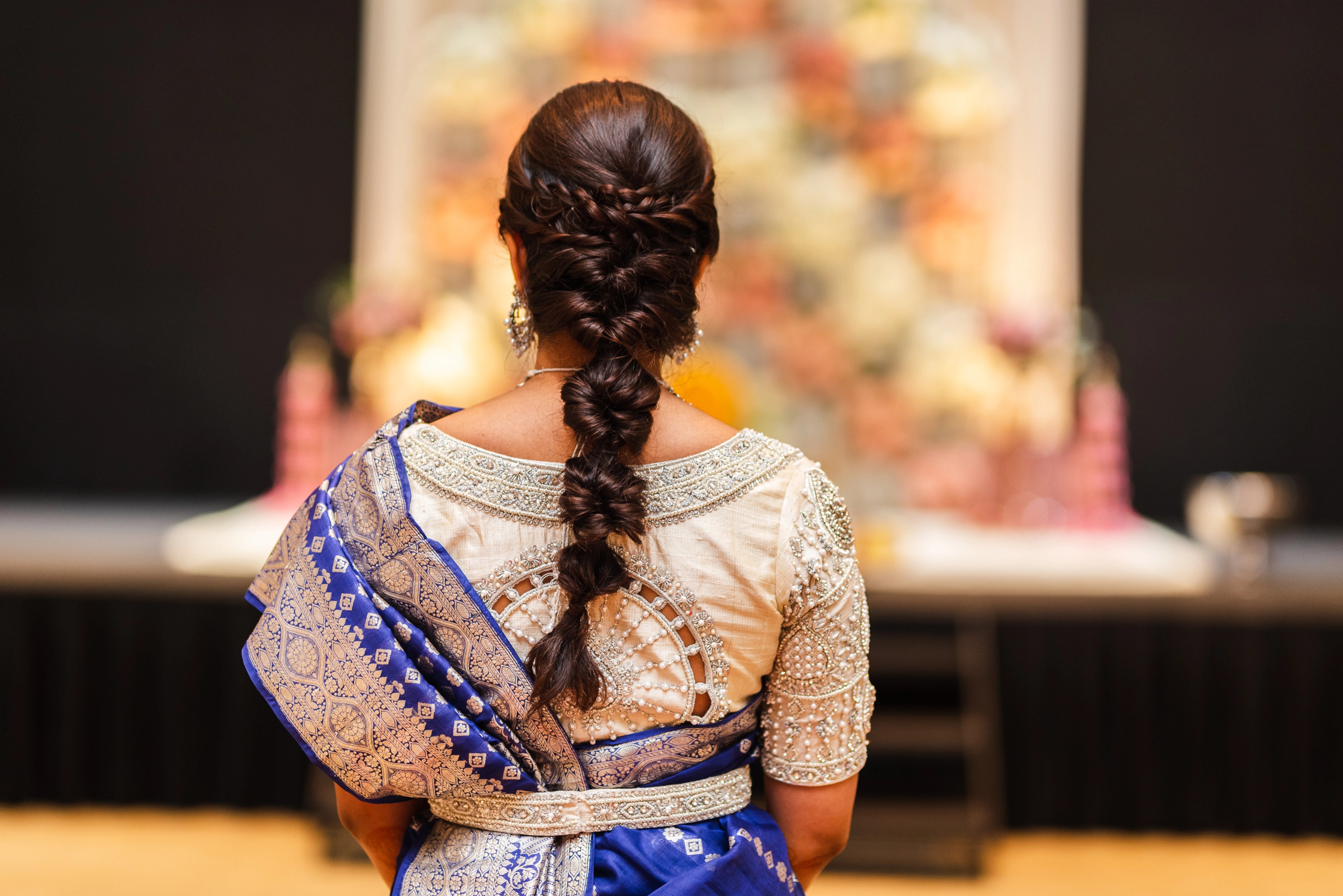 Bride Anusha R from Malaysia showcasing back blouse design in an ivory concept raw silk blouse & belt, intricately handcrafted with zardosi, beads, stones and pearls by team Archana Karthick.