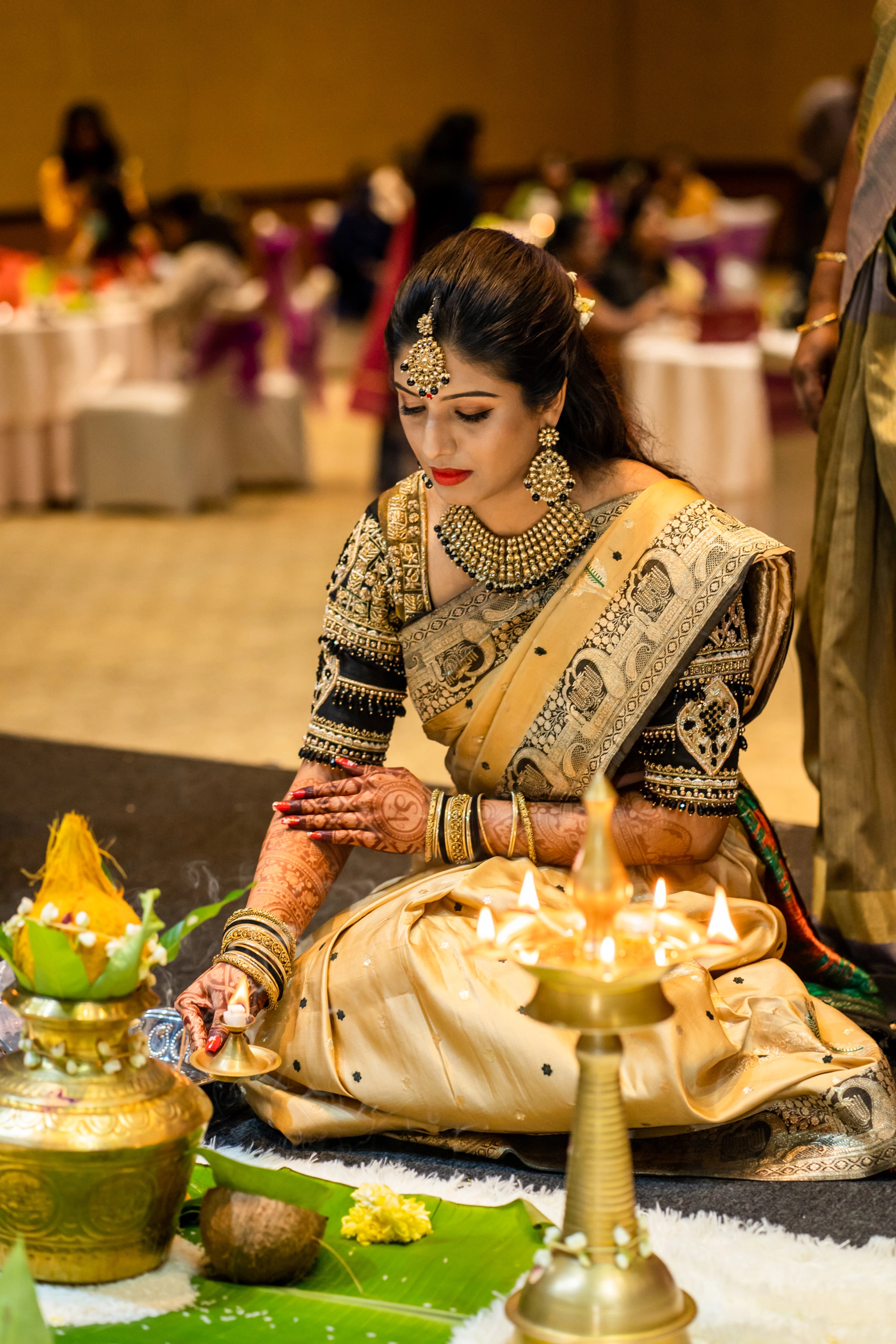 Bride Anusha from Malaysia seated in a black raw silk blouse by team Archana