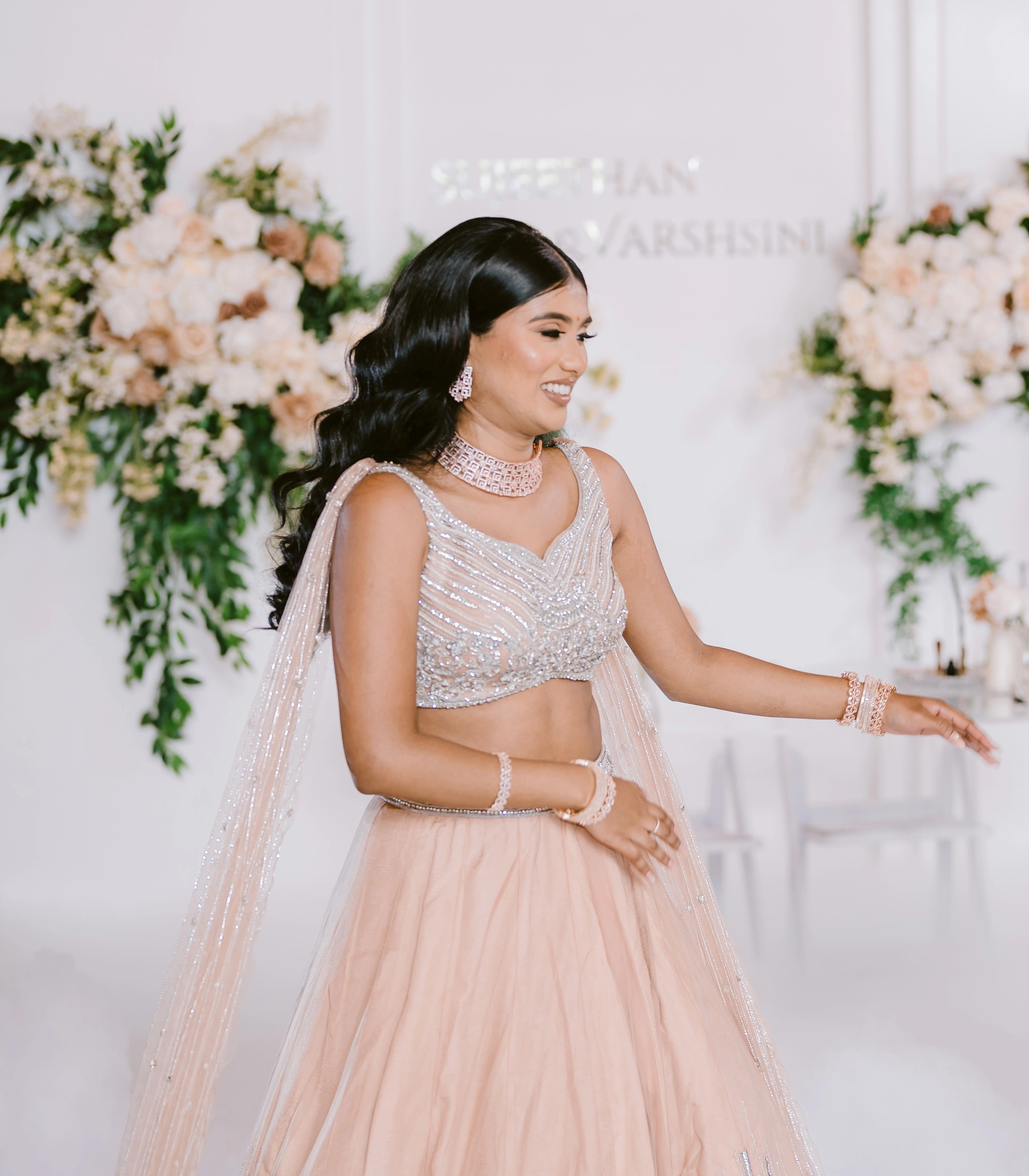 Bride Apy from Canada posing in a blush (shades of peach cream) lehenga, handcrafted by team Archana Karthick.