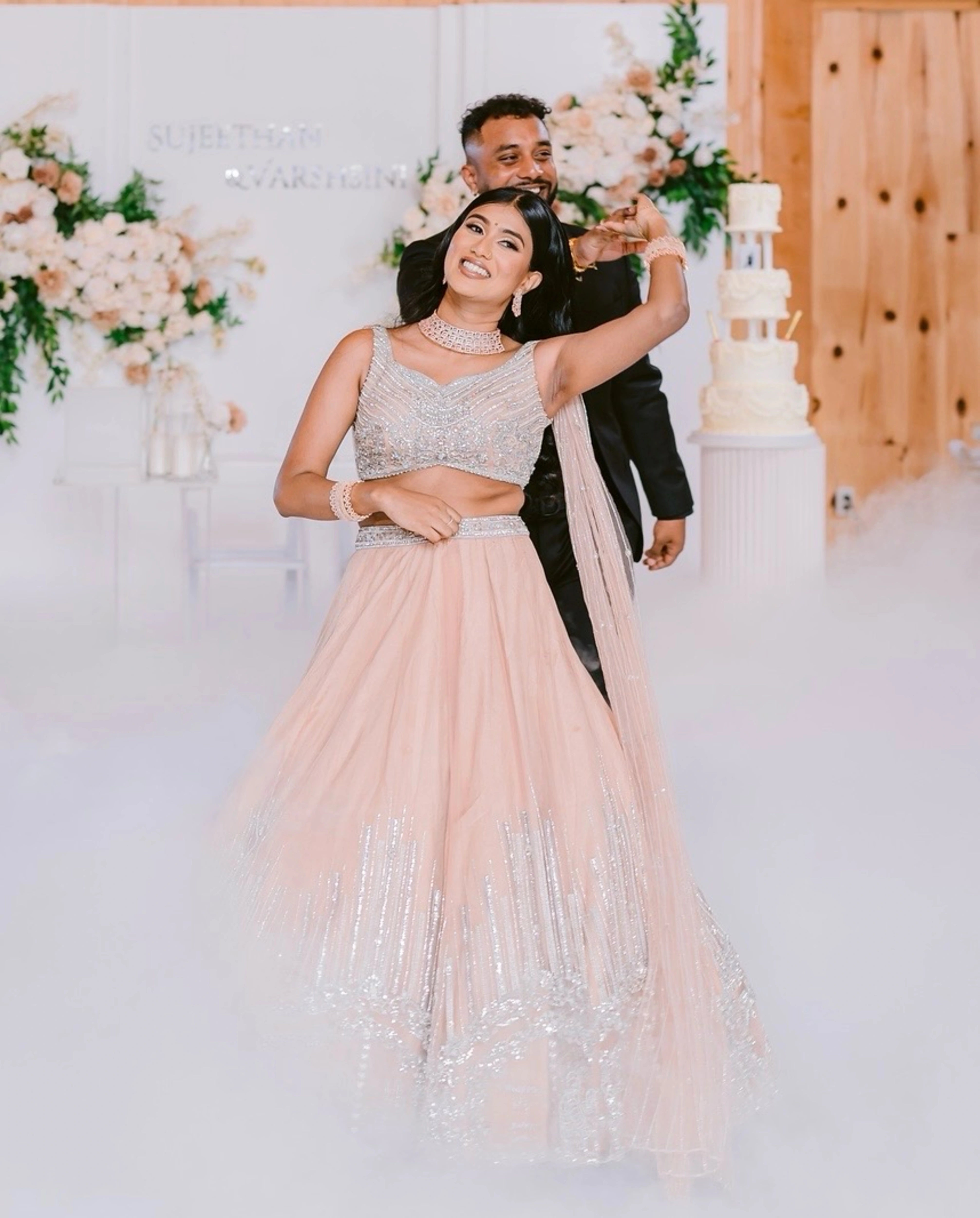 Bride Apy from Canada smiling in a blush (shades of peach cream) lehenga, handcrafted by team Archana Karthick.