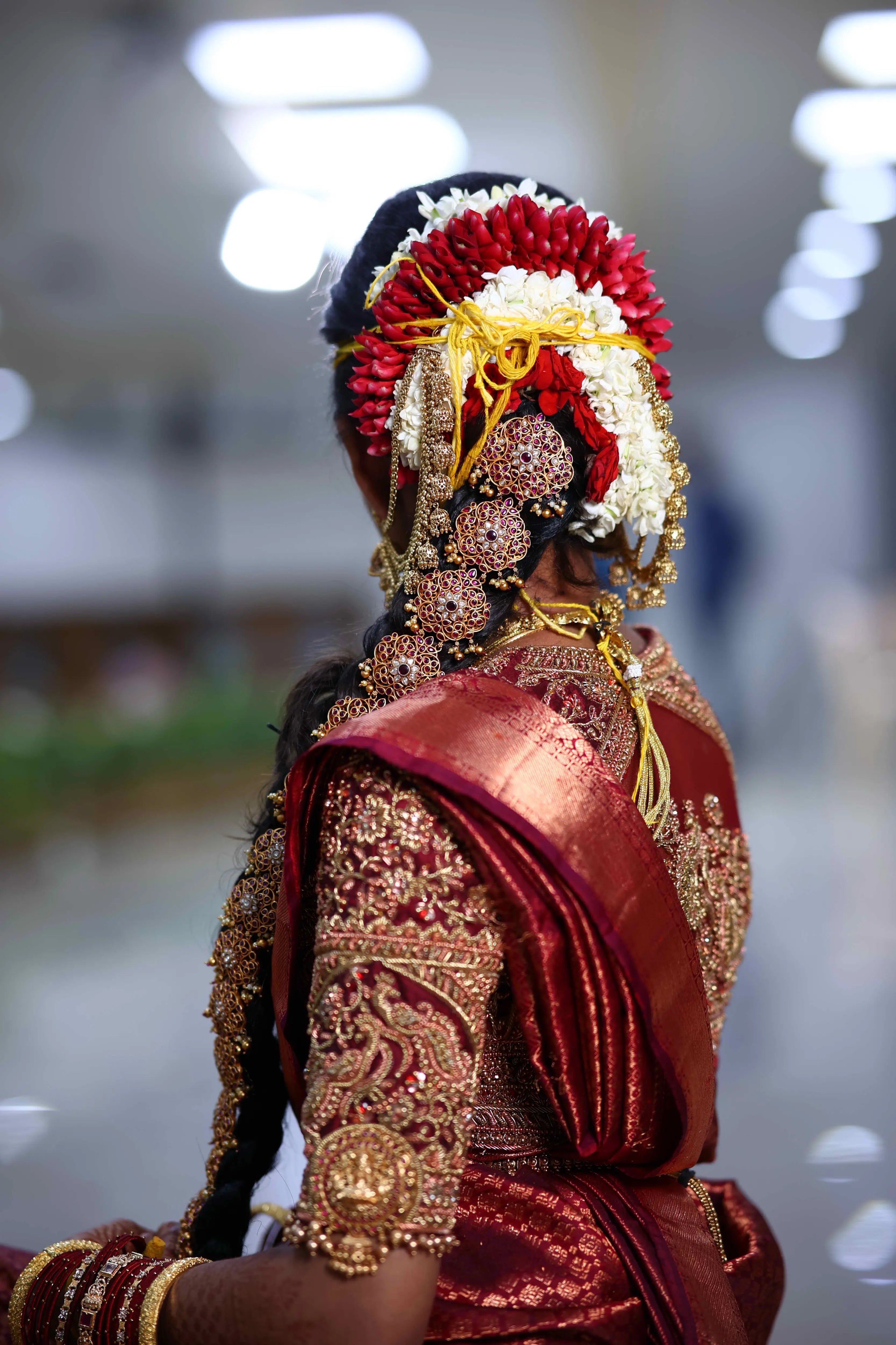 Bride Ashwathi from Dindigul in a maroon concept silk blouse, intricately handcrafted with zardosi, beads, kundan, sequins and kemp stones by team Archana Karthick.