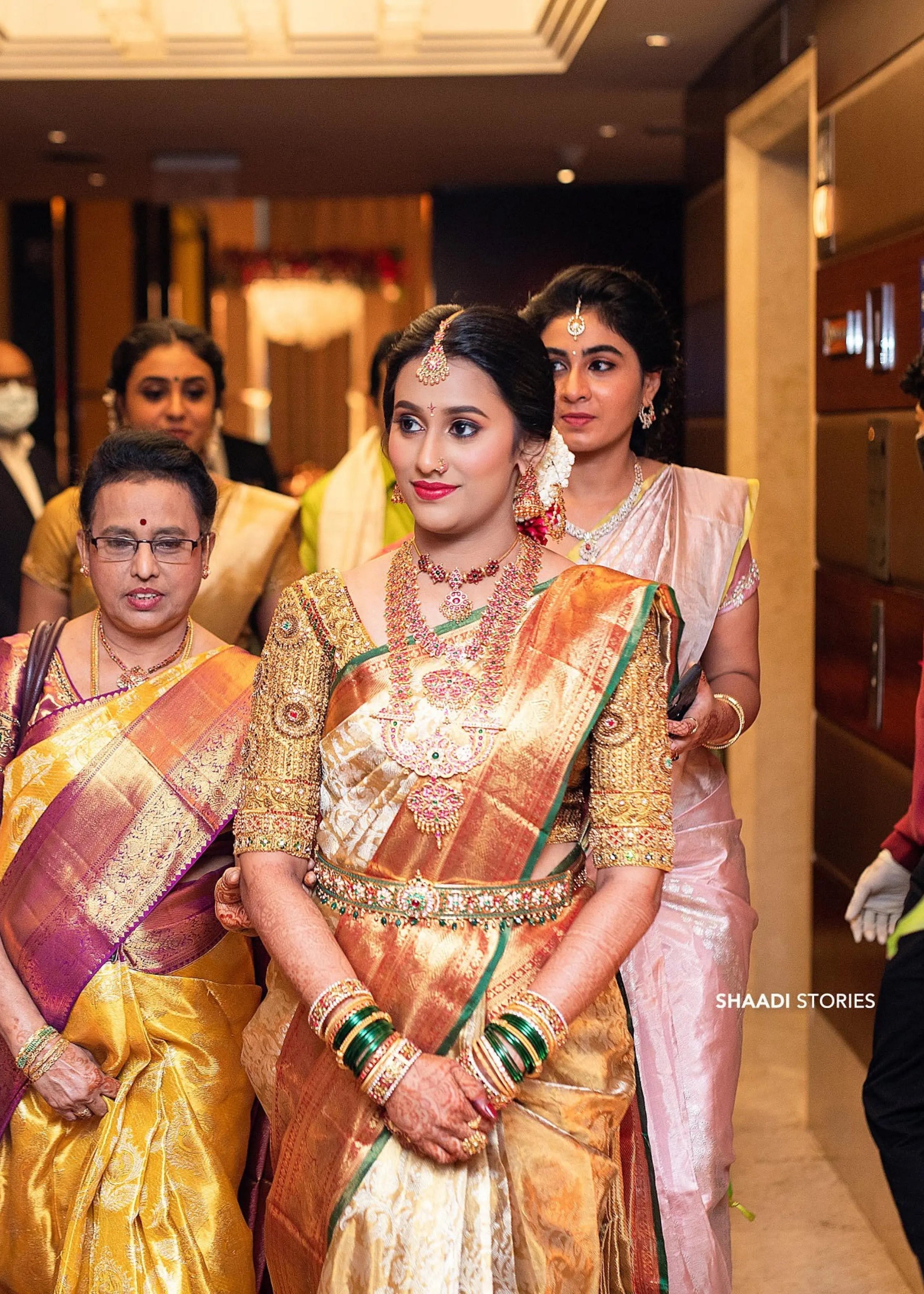 Bride Ashwini posing in a gold silk blouse handcrafted by team Archana Karthick.