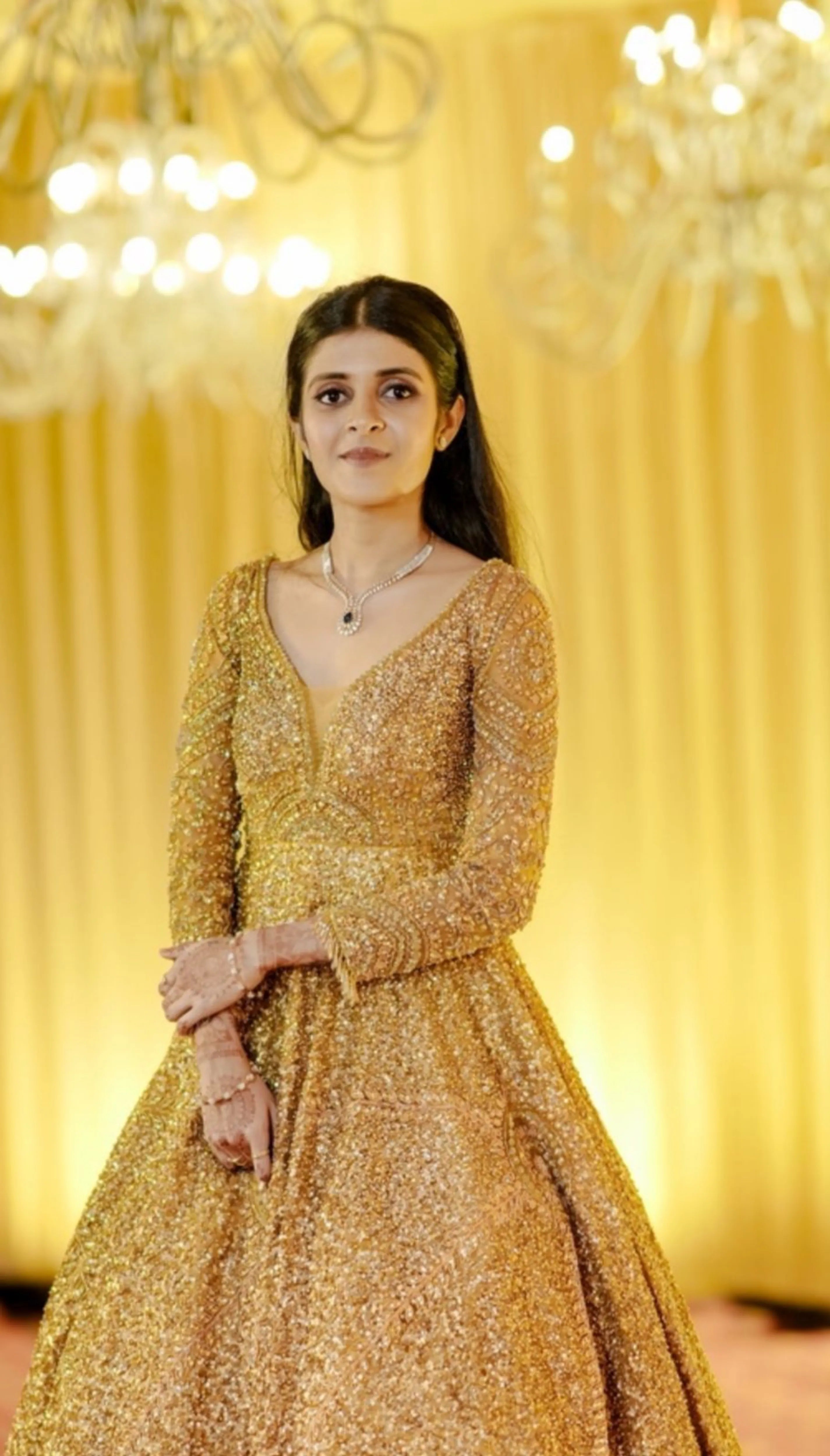 Bride Aswathi posing in a tulle gold gown handcrafted by team Archana Karthick.