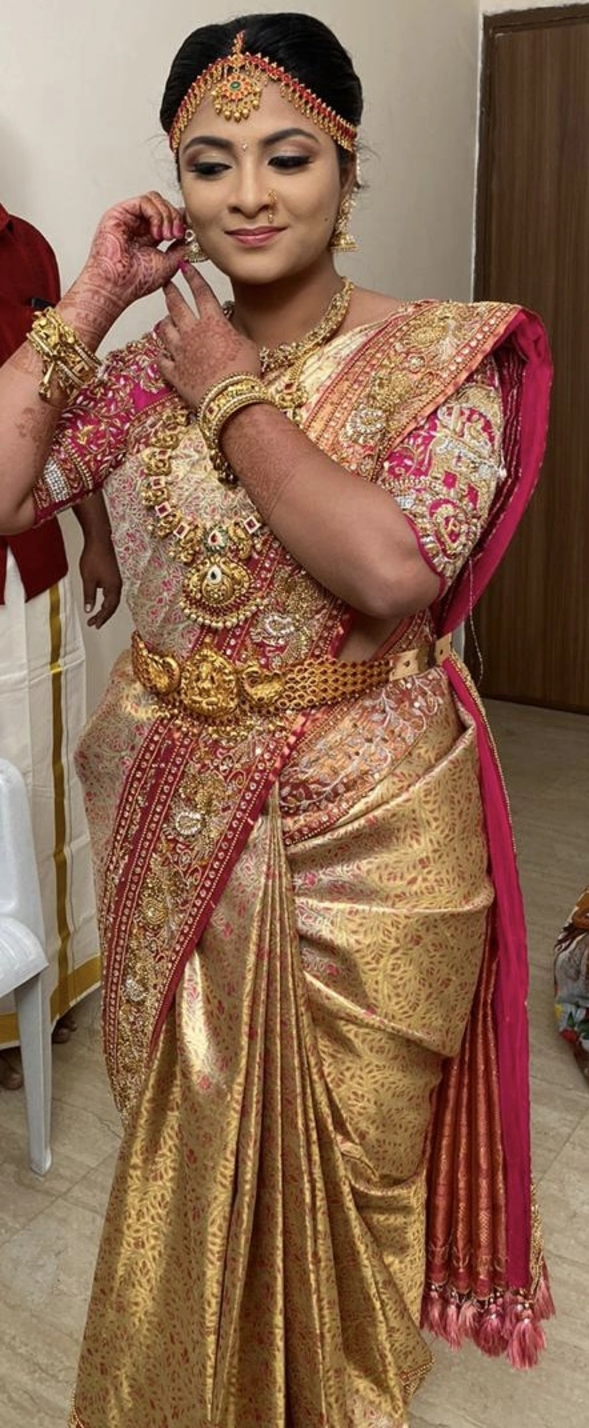 Bride Barani Lekha smiling in an intricately handcrafted pink silk blouse and saree border with zardozi, beads, stones, sequins and hangings by team Archana Karthick.