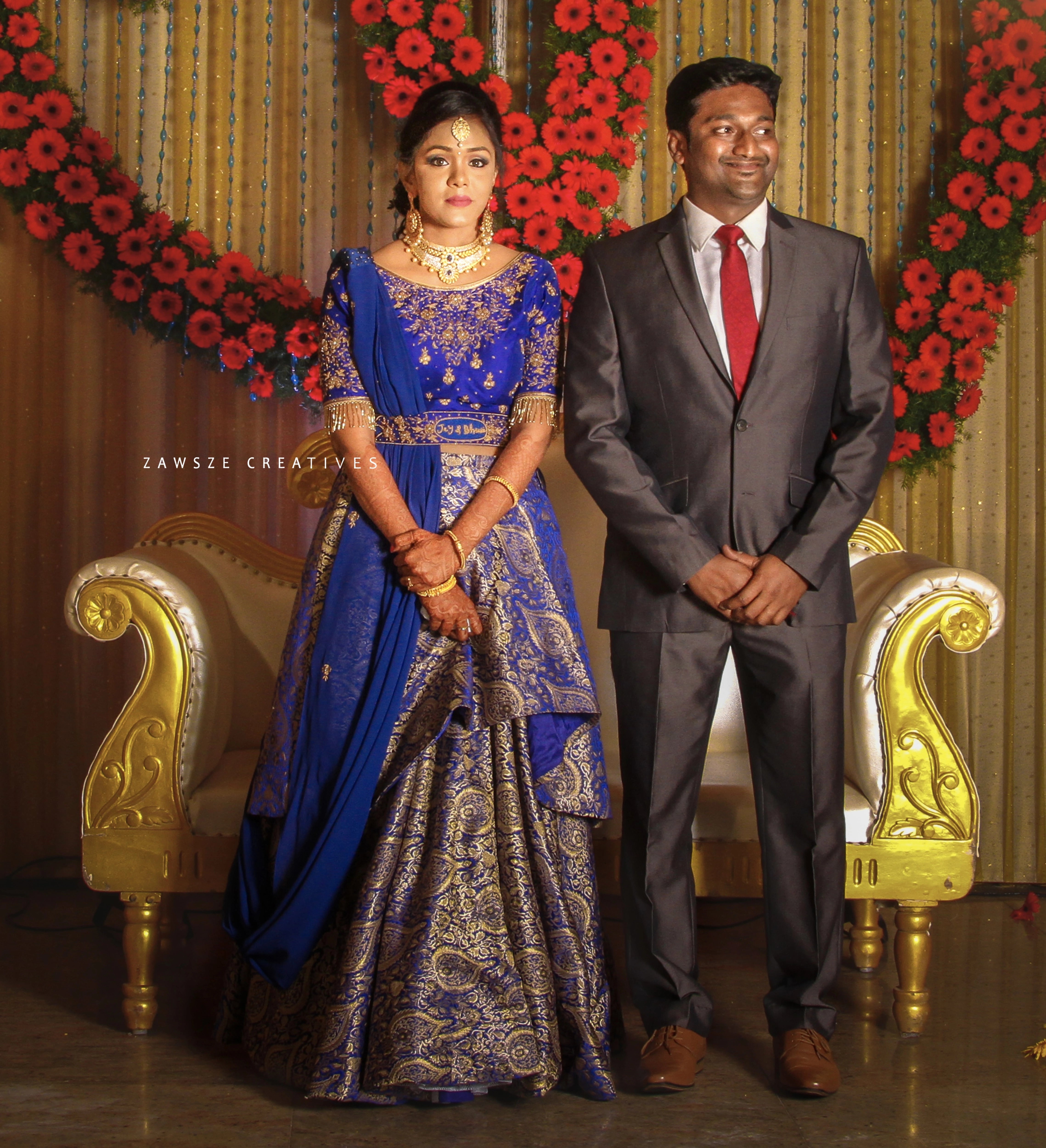 Bride Bhuvana from Chennai posing with groom in a blue and silver brocade with belt, intricately handcrafted with beads and zardozi by team Archana Karthick.